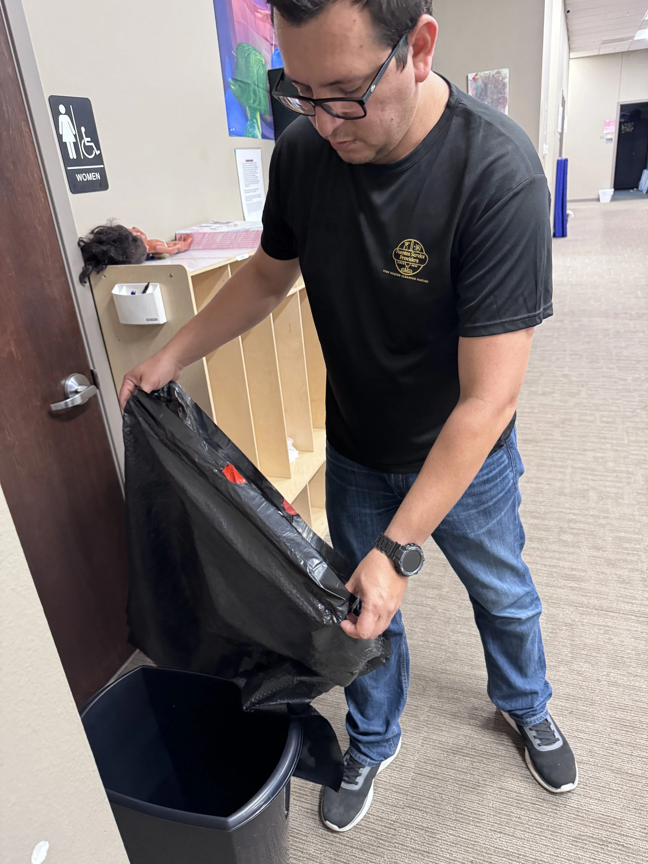 Fuentes Service Providers team member taking out trash during a commercial cleaning service