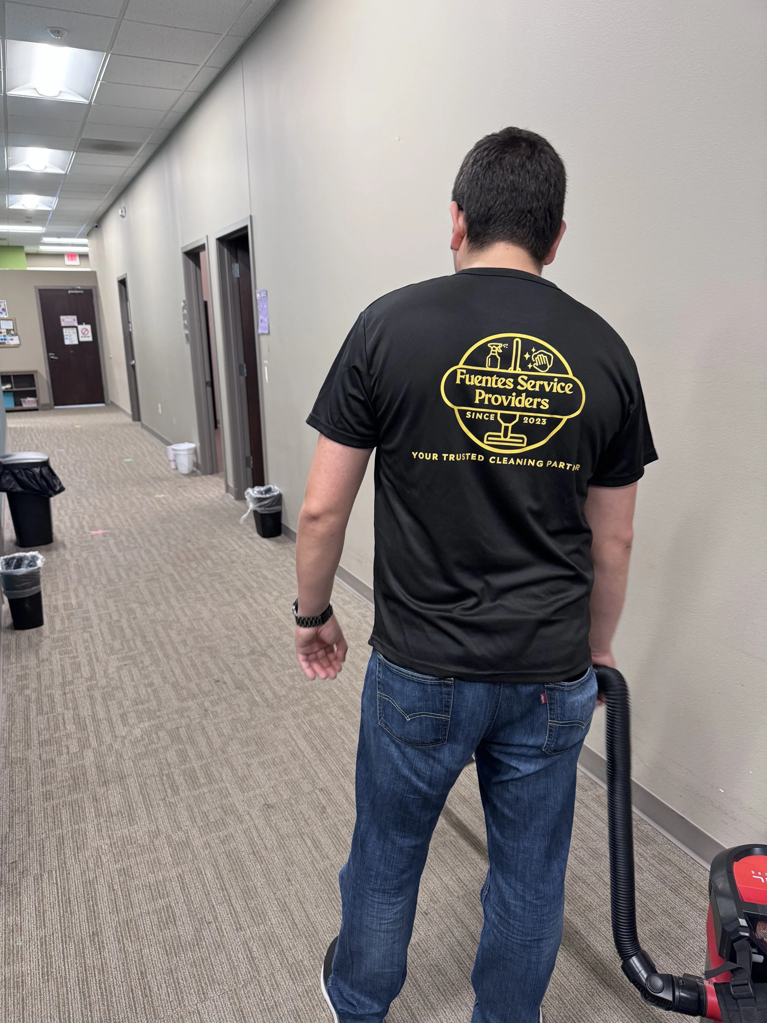 Fuentes Service Providers team member cleaning an office hallway