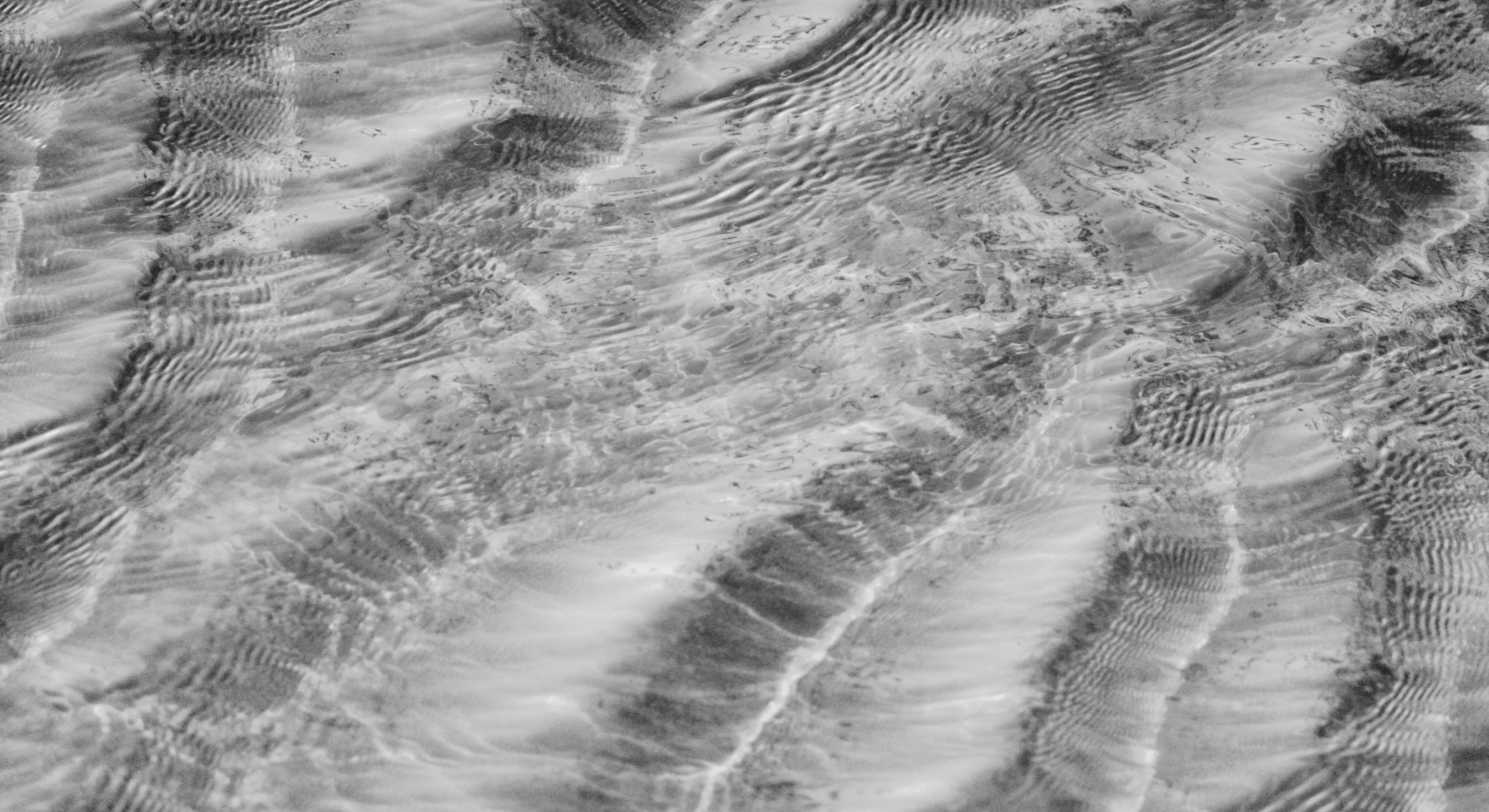 Superficie de agua con ondas suaves, que representa el equilibrio y la fluidez del bienestar en Tess.