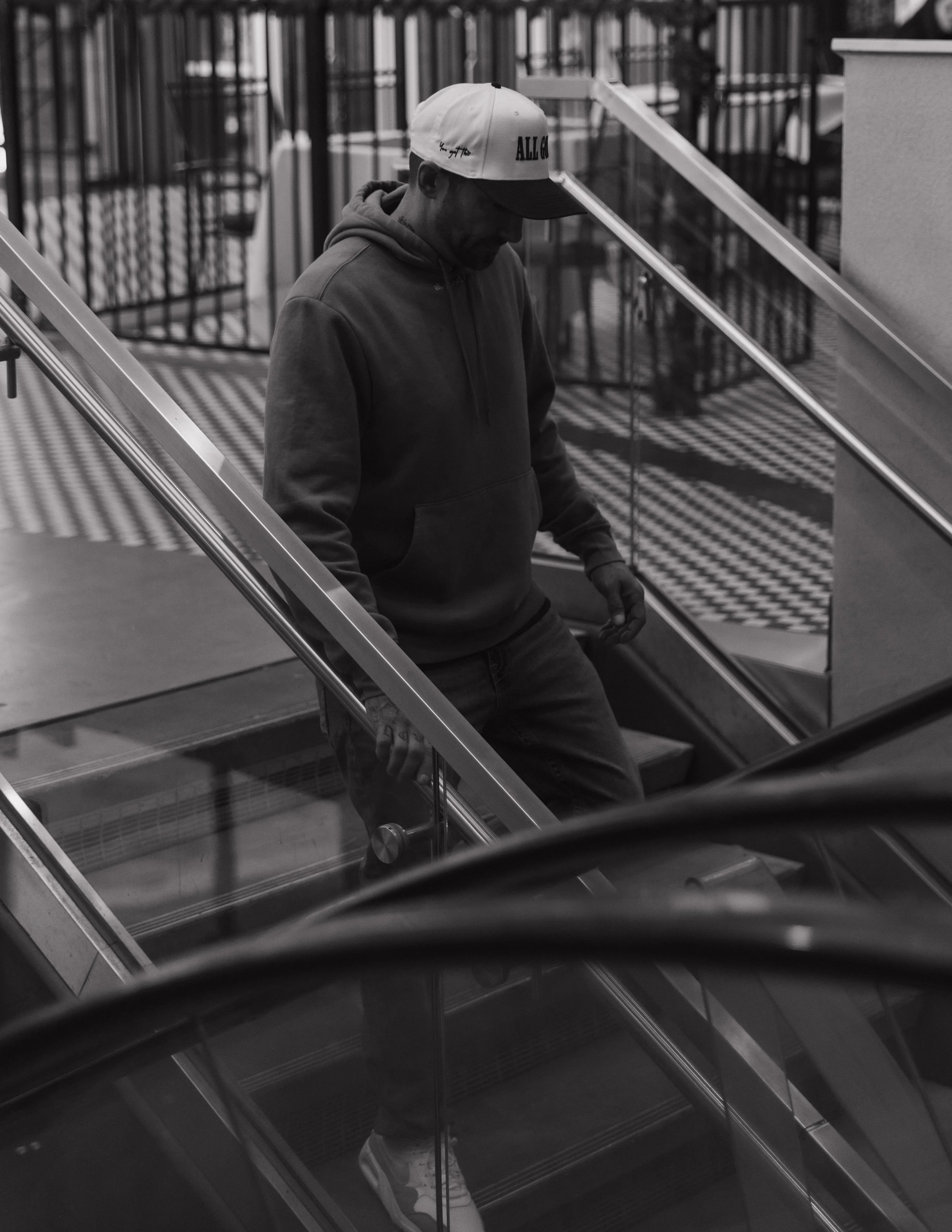 Founder of ALL GOOD CO. walking down stairway wearing a ALL GOOD CO. hat and hoodie.