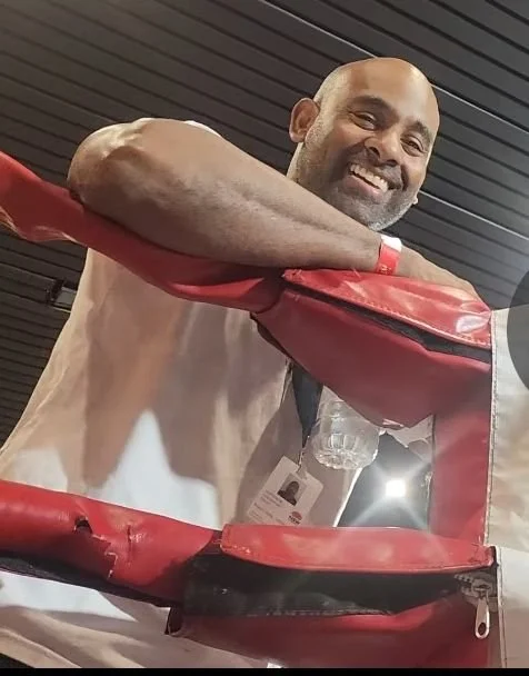 Coach Nish of Precision Boxing Performance beside a boxing ring
