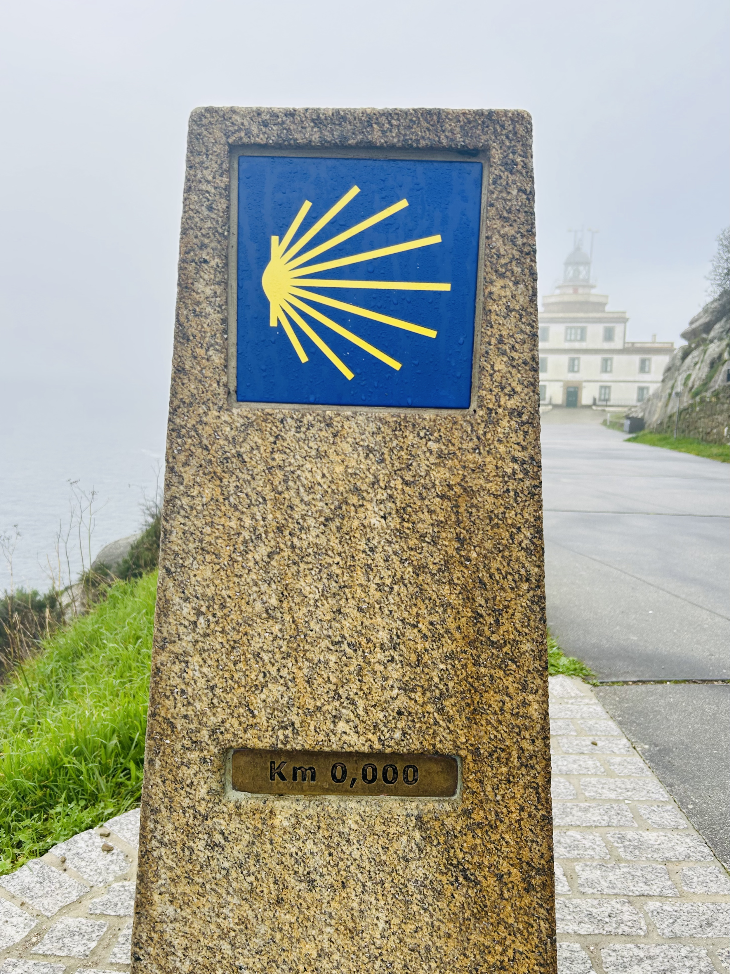Borne kilométrique du Chemin de Compostelle marquant le kilomètre 0, avec le symbole de la coquille Saint-Jacques.