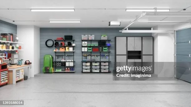 Empty garage with shelves containing tools, storage bins, and sports equipment.