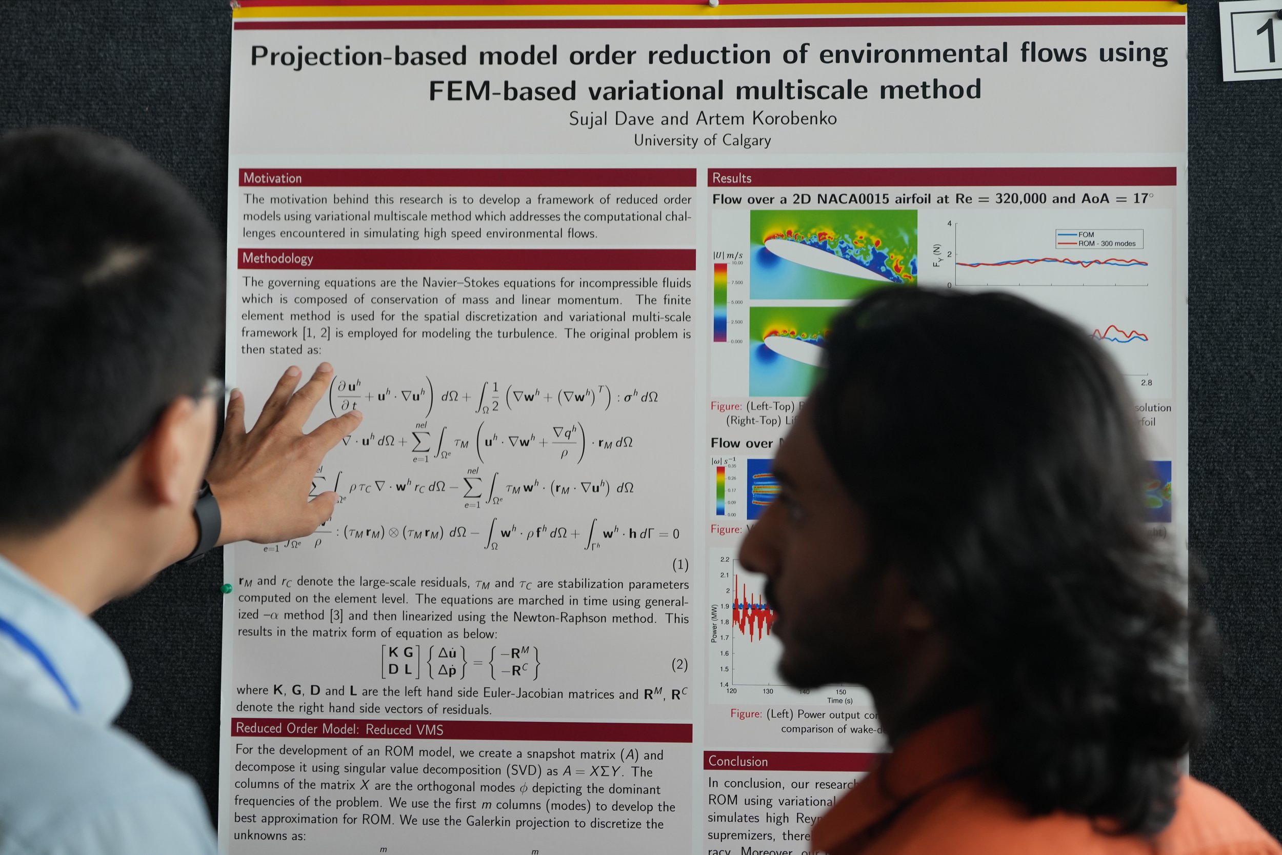 A research poster titled "Projection-based model order reduction of environmental flows using FEM-based variational multiscale method" is displayed. Two individuals are viewing the poster, which contains text, equations, and graphs related to the research.