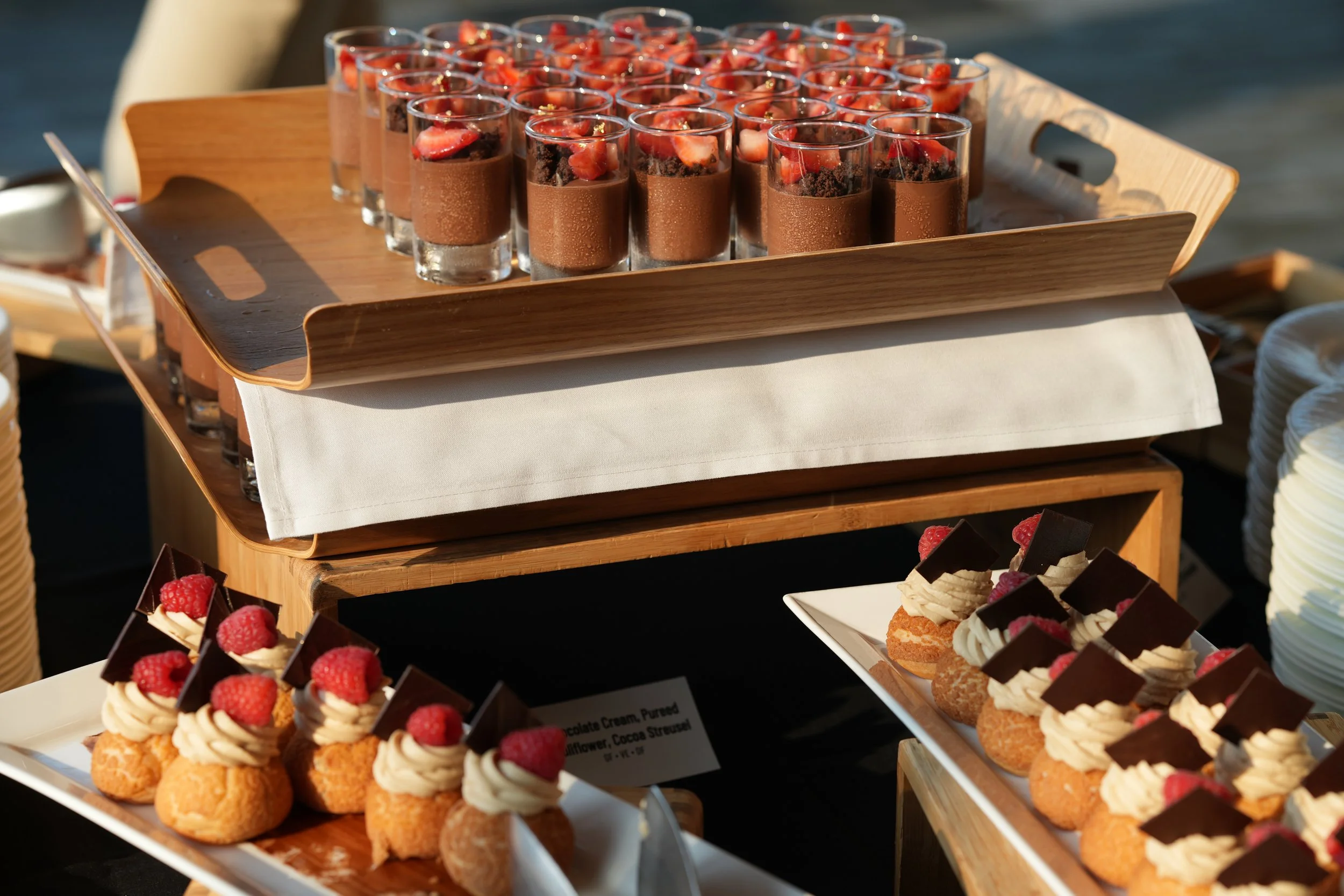Tray of chocolate mousse cups topped with strawberries and crumbled cookies