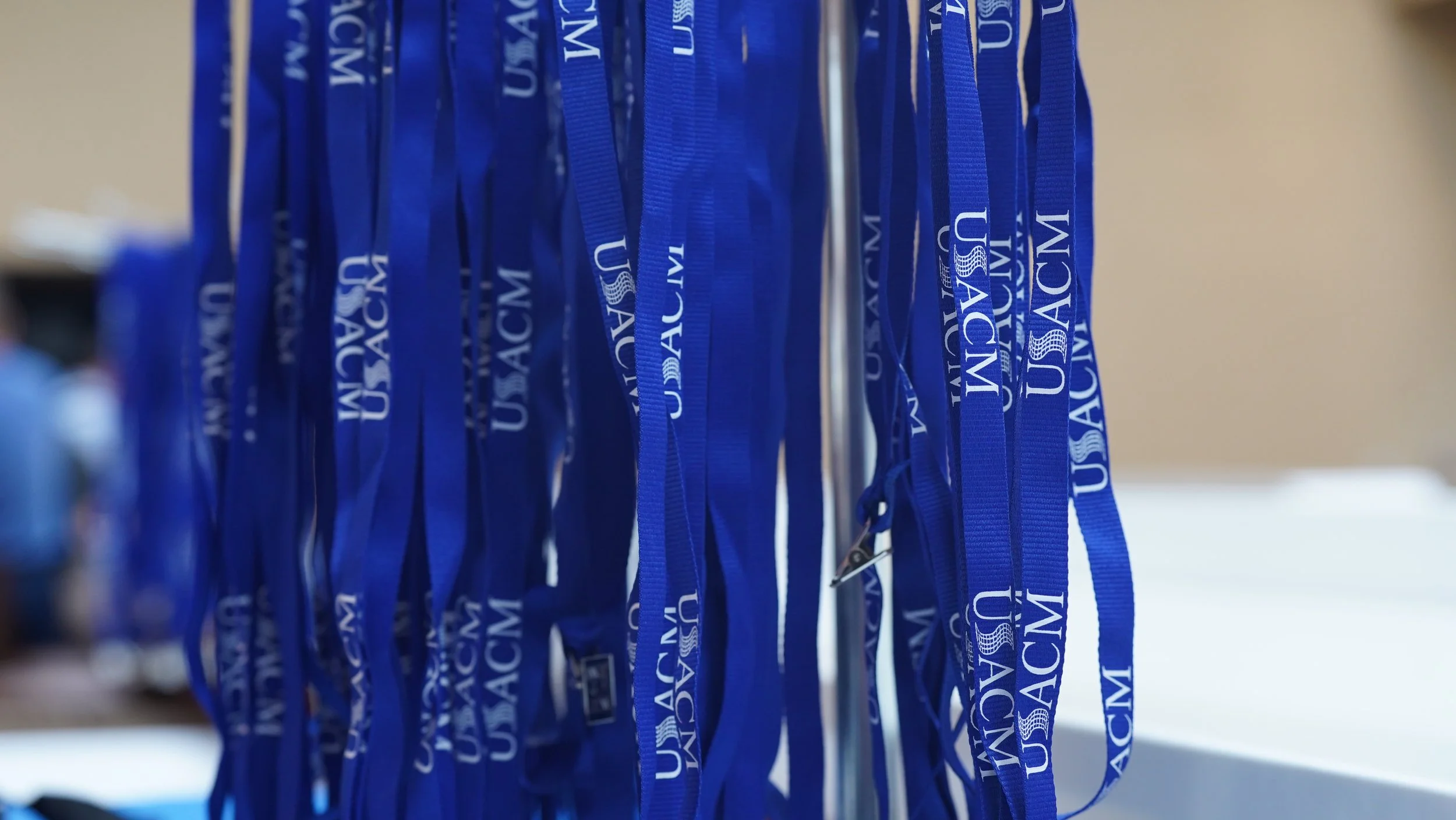 Blue lanyards hanging on a rack with 'U.S. Army WAMC' printed on them.