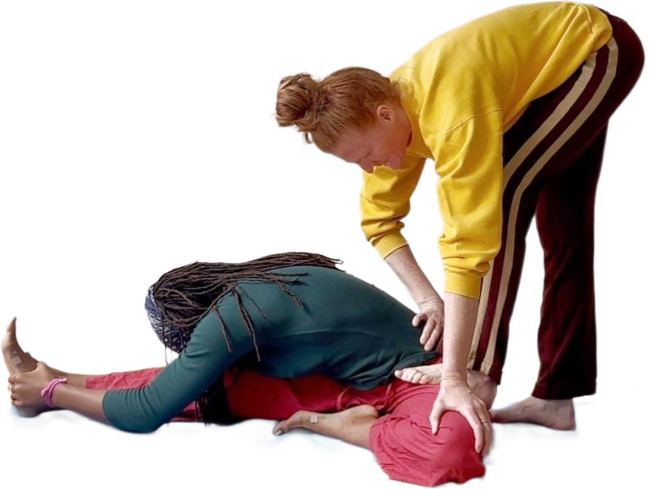 Two people practicing first aid, one person is lying down and the other is providing rescue breathing or CPR.