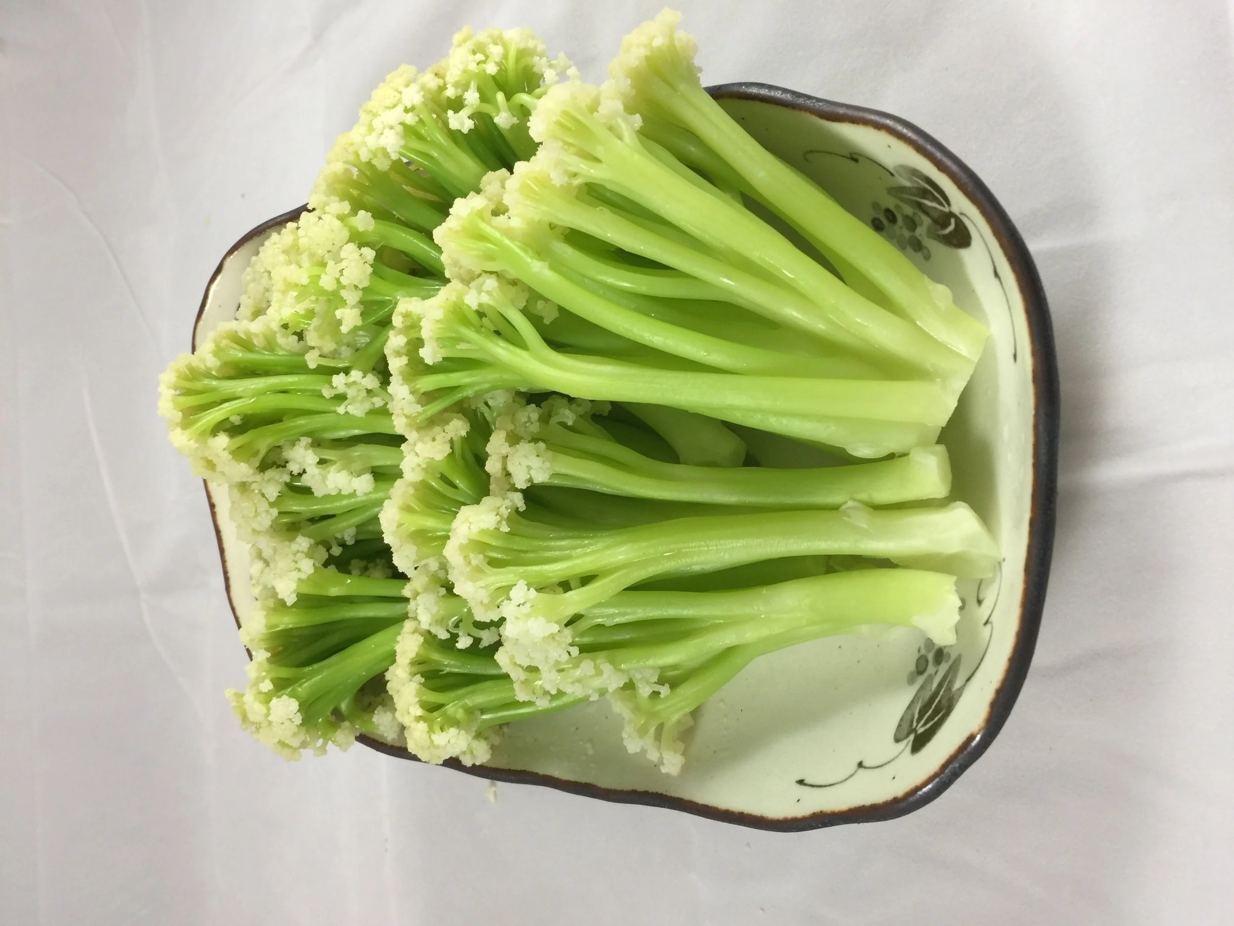 Fresh broccoli florets in a decorative bowl.
