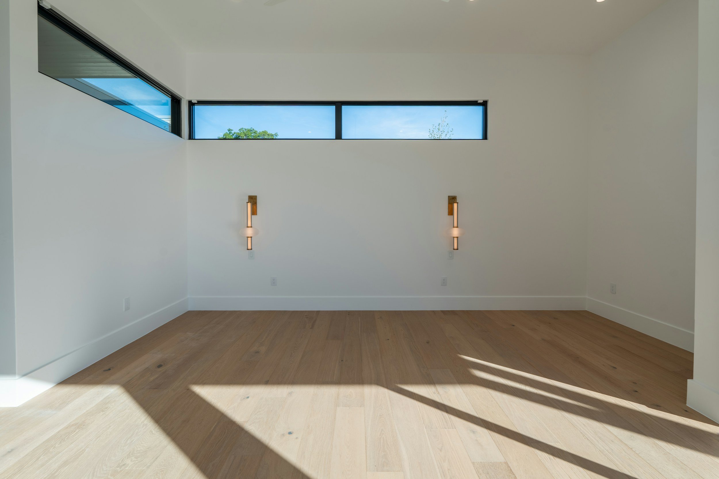 Bright, sunlit room with new hardwood flooring.