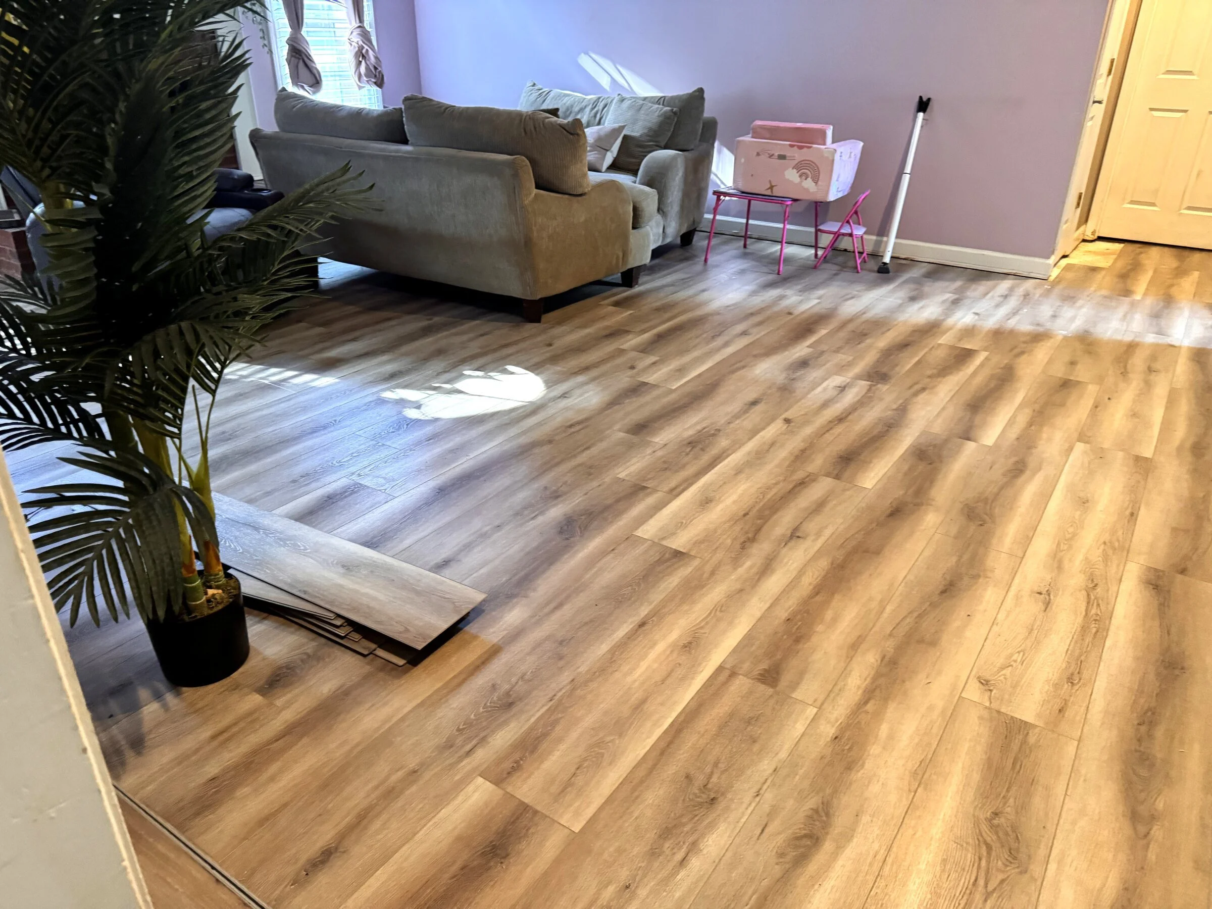 Completed luxury vinyl plank flooring installation across an open Atlanta-area living room