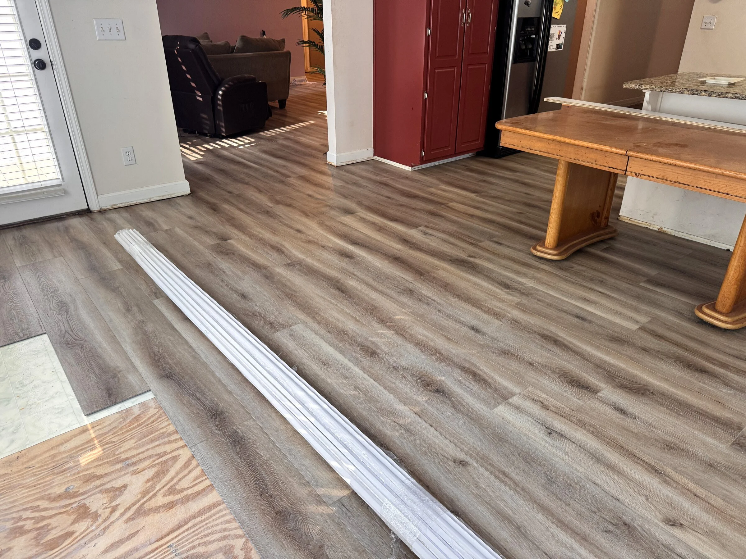 Continuous luxury vinyl plank flooring transition between living and kitchen spaces in an Atlanta-area home