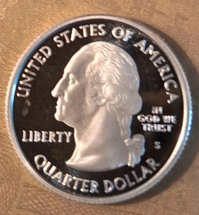 Close-up of a United States quarter-dollar coin showing a profile of George Washington.