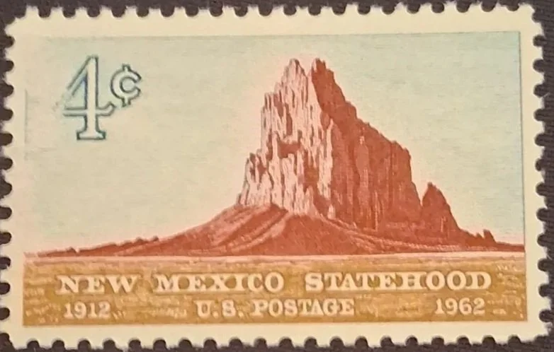 A vintage Mexican postage stamp featuring a depiction of a mountain or rock formation, with text indicating it commemorates 50 years of New Mexico statehood from 1912 to 1962, and has a denomination of 4 cents.