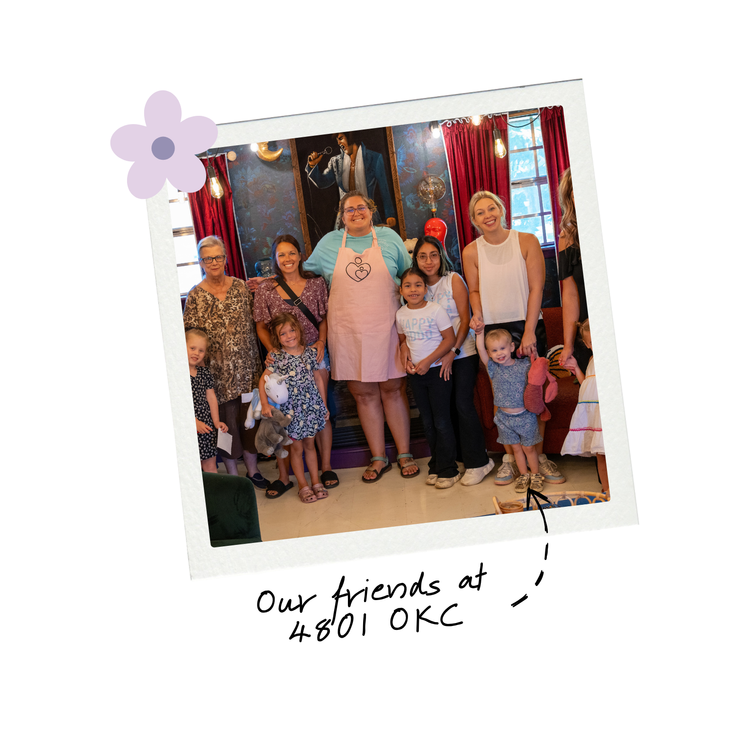 Women and children pose together in a decorated room.