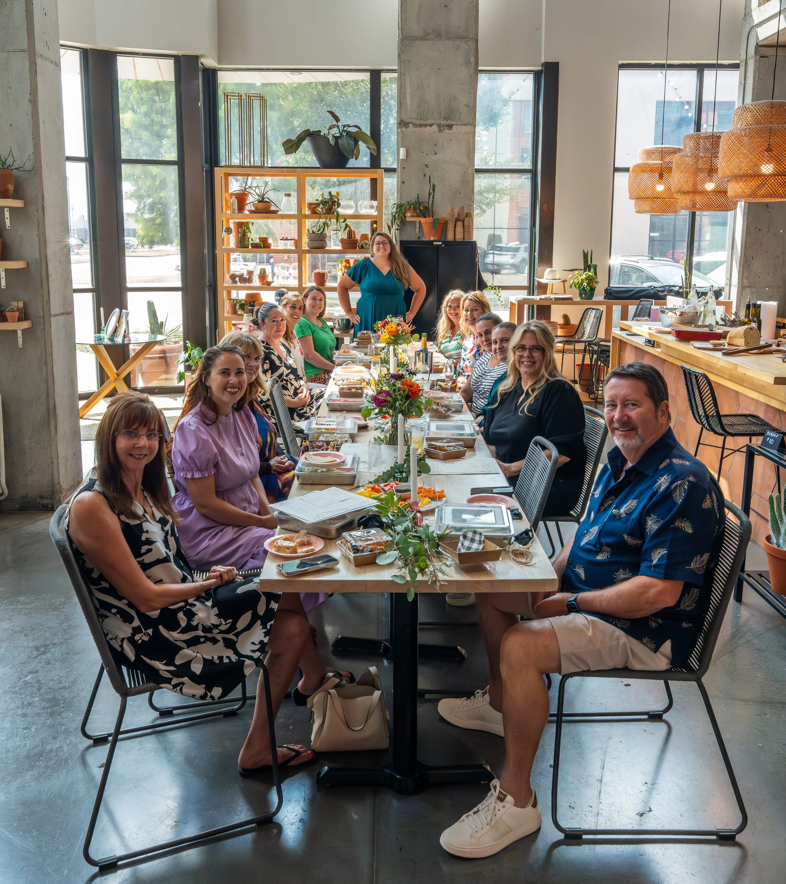 A group of men an women gathered for a sourdough class surrounded by large windows.