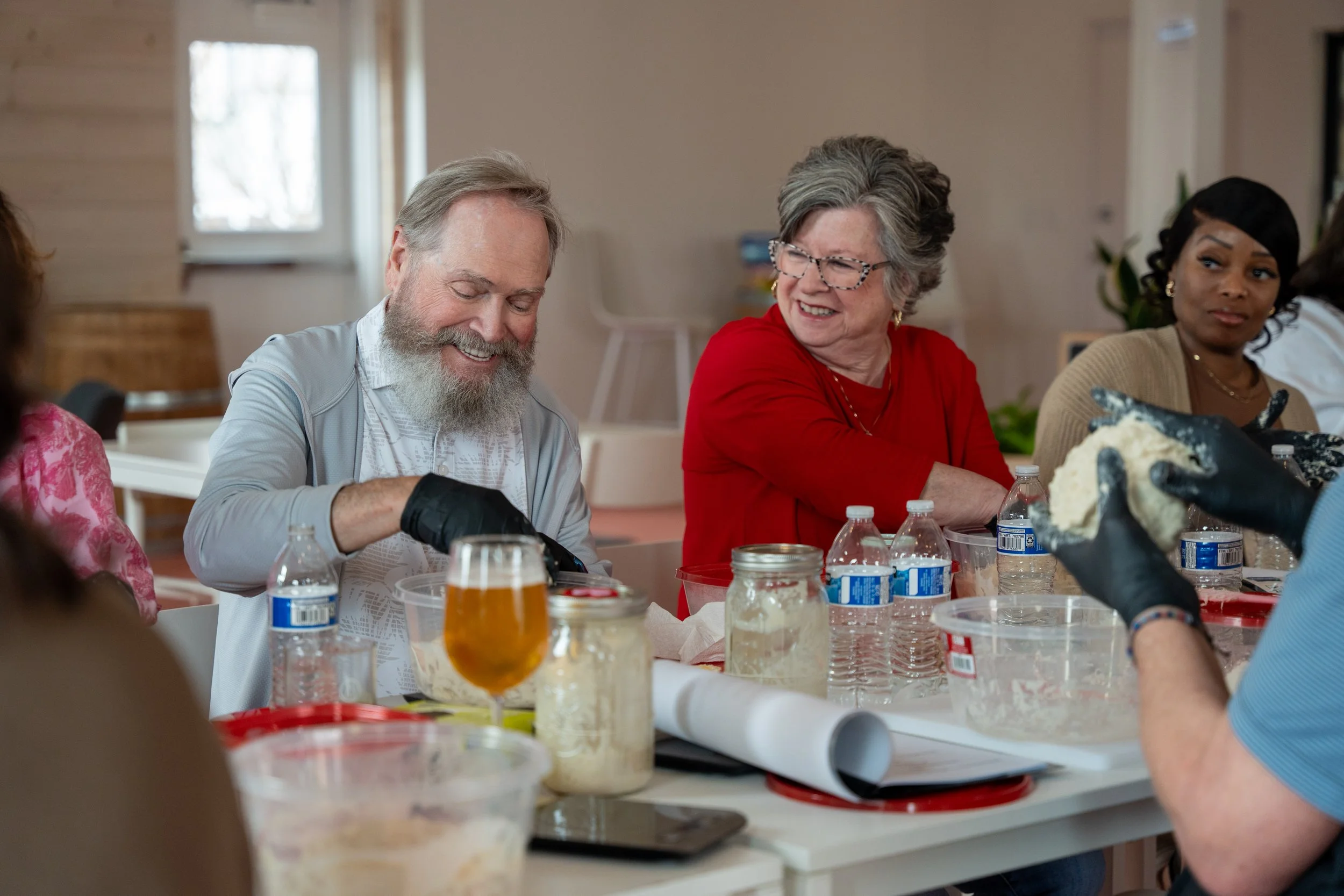 Sourdough class participants sitting at a table kneading sourdough.