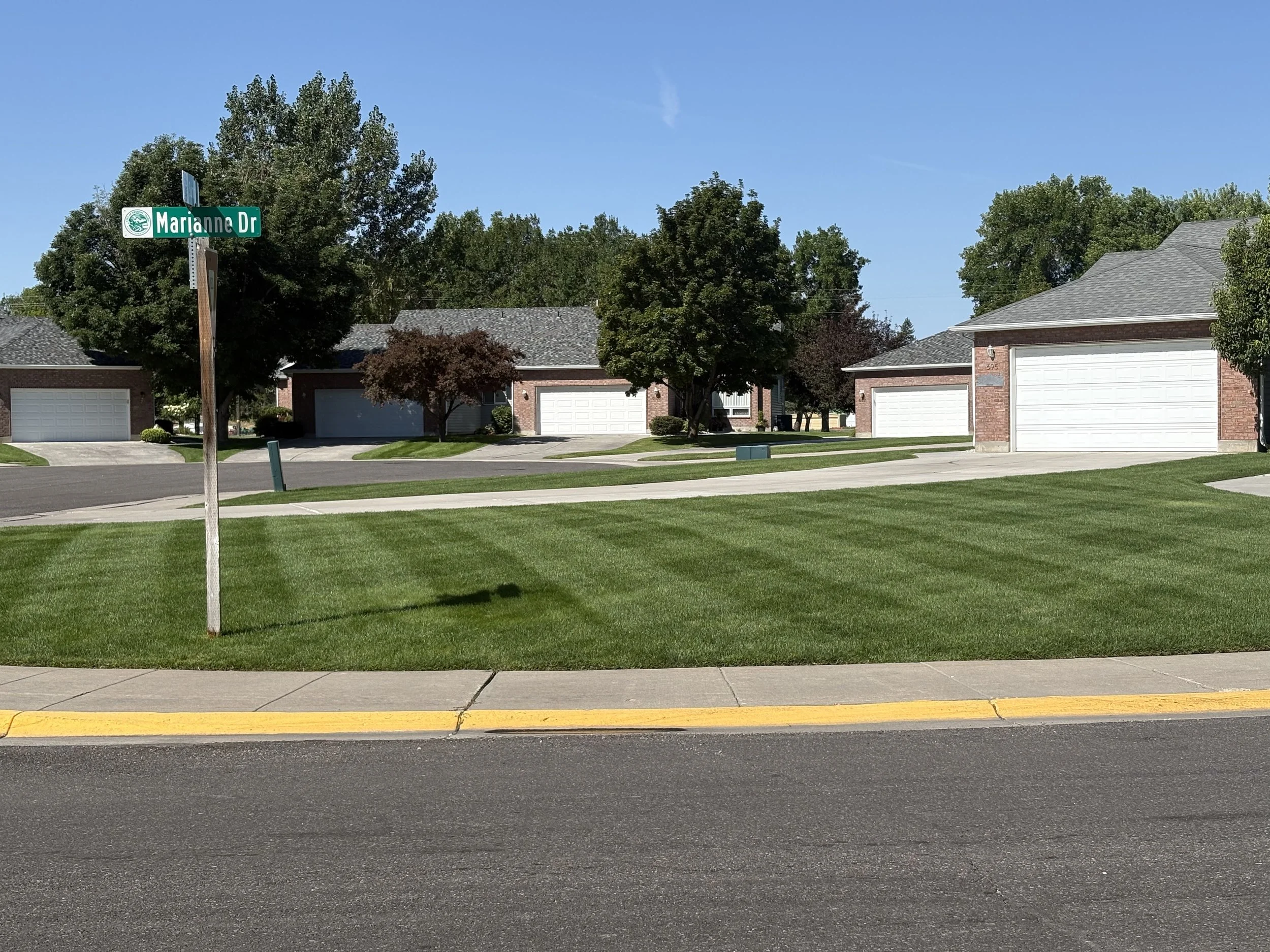 A freshly mowed lawn with alternating dark and light strips of grass. 