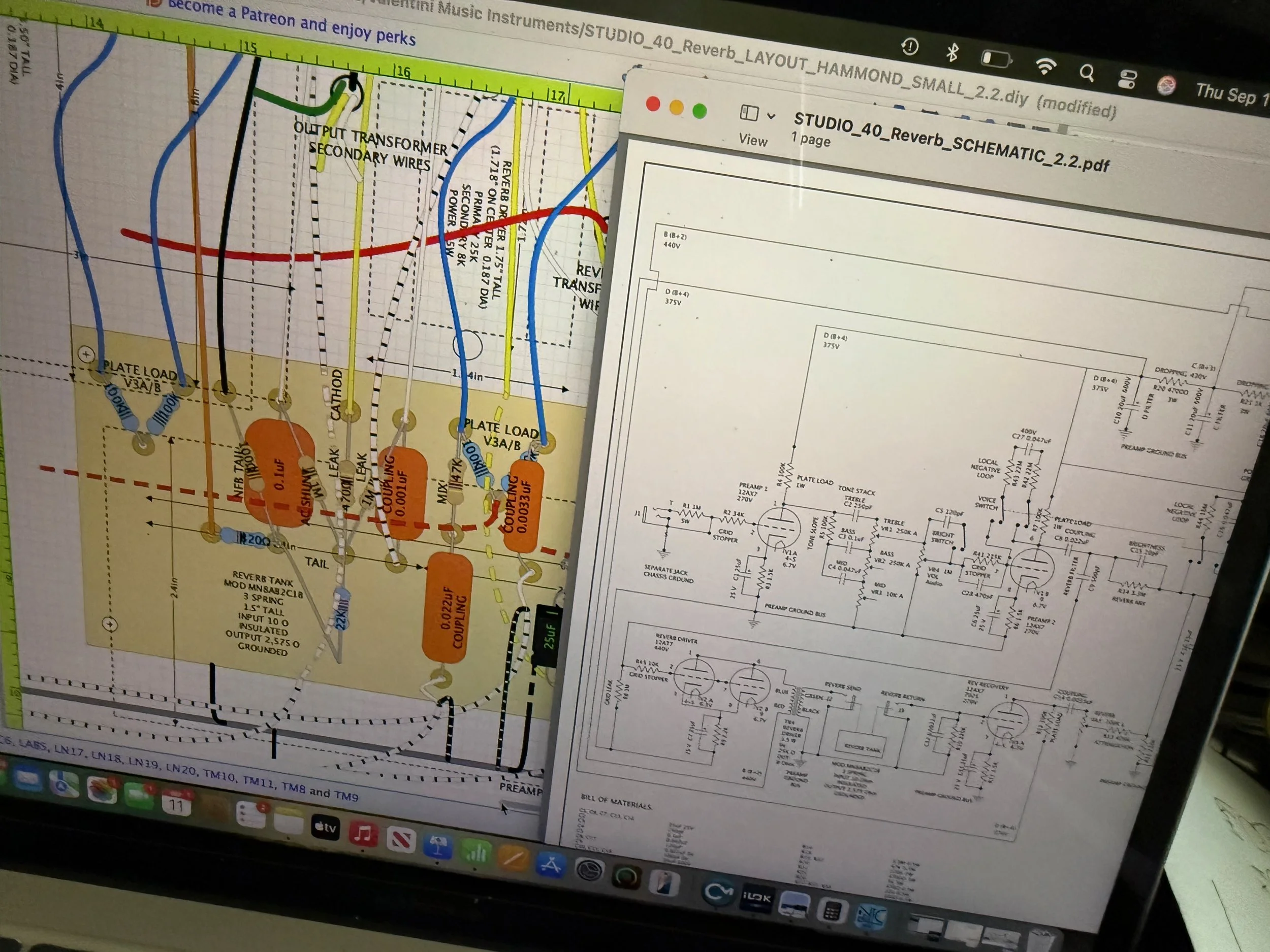 A computer screen displaying a schematic diagram of an audio amplifier or reverb circuit, with colored wires and labels, partially obscured by a printed schematics sheet.