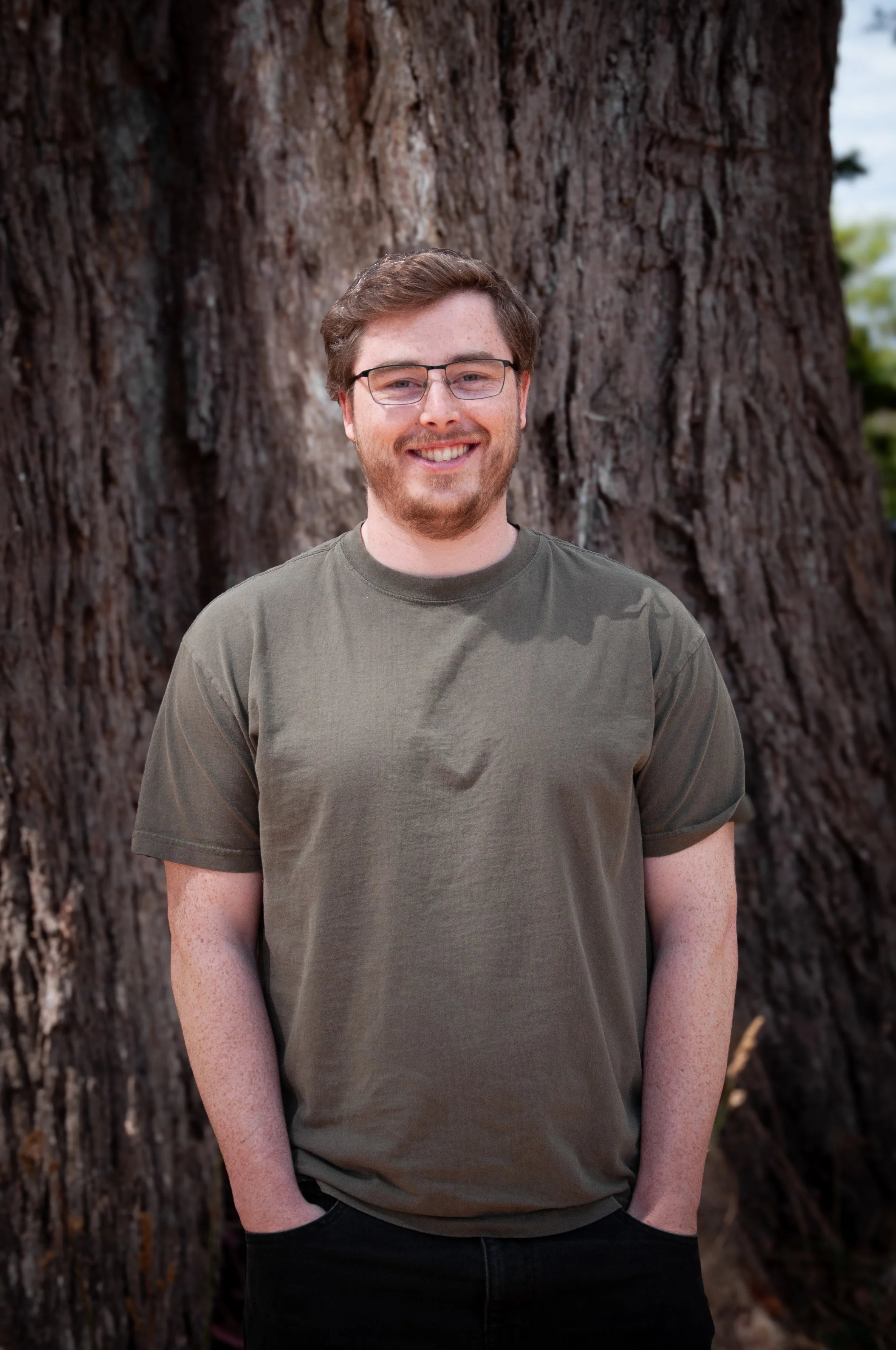 Toby standing in front of a large eucalyptus tree, smiling at the camera.