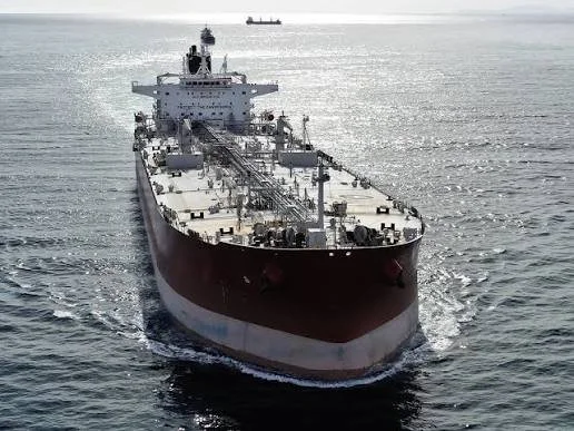 A large black oil tanker ship sailing on the ocean.