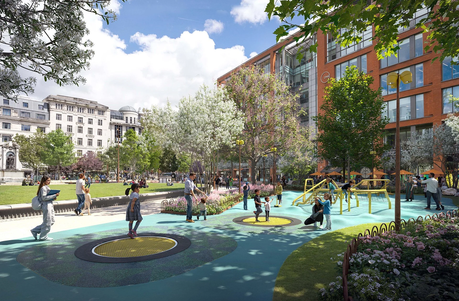 Children and adults playing on trampolines in a colorful urban park with trees, flowers, and modern buildings in the background on a sunny day.