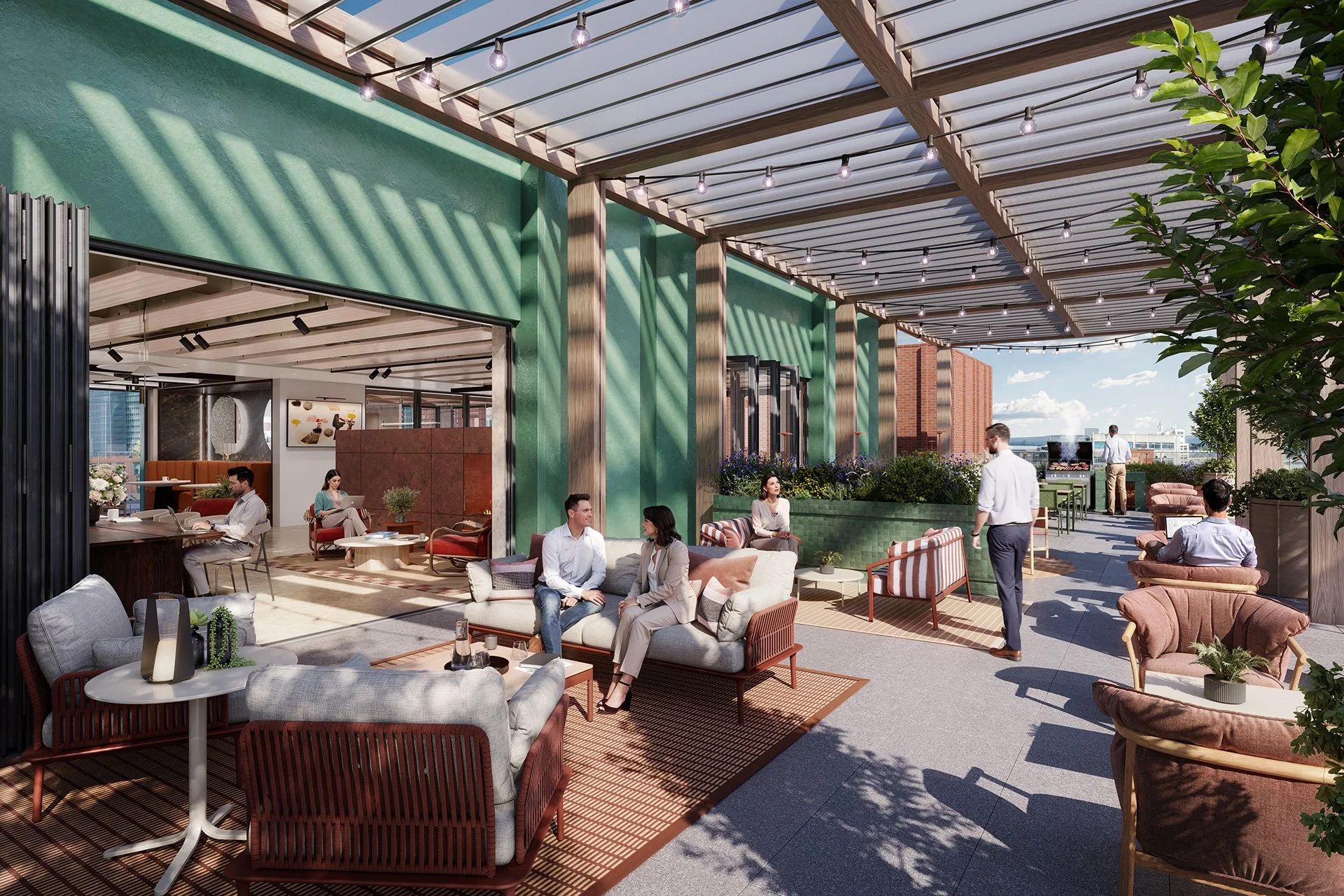 Rooftop lounge area with people seated on sofas and chairs, string lights overhead, greenery, and city buildings in the background on a sunny day.