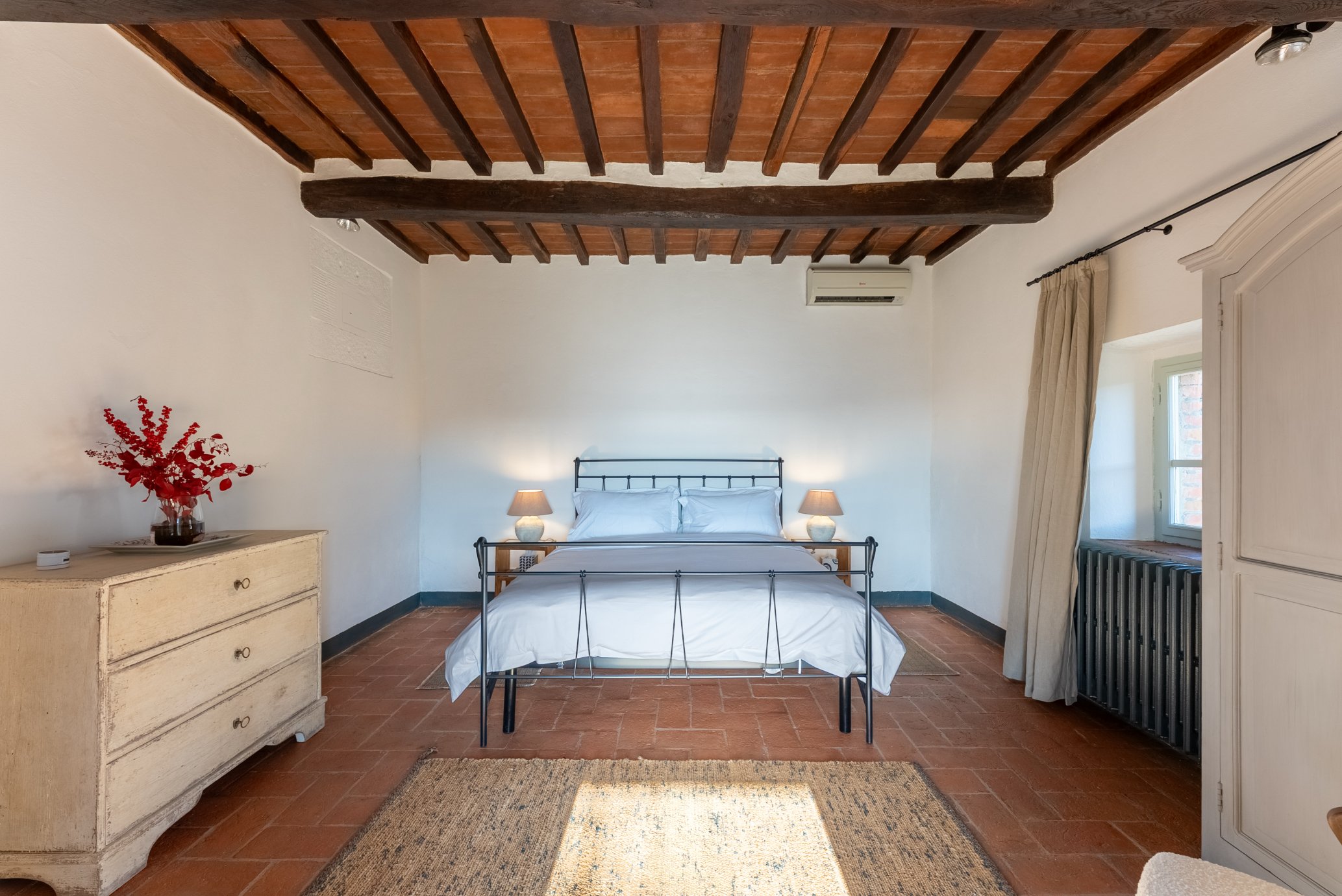 Bedroom at La Casa Cappellina with original terracotta floors and ceilings.