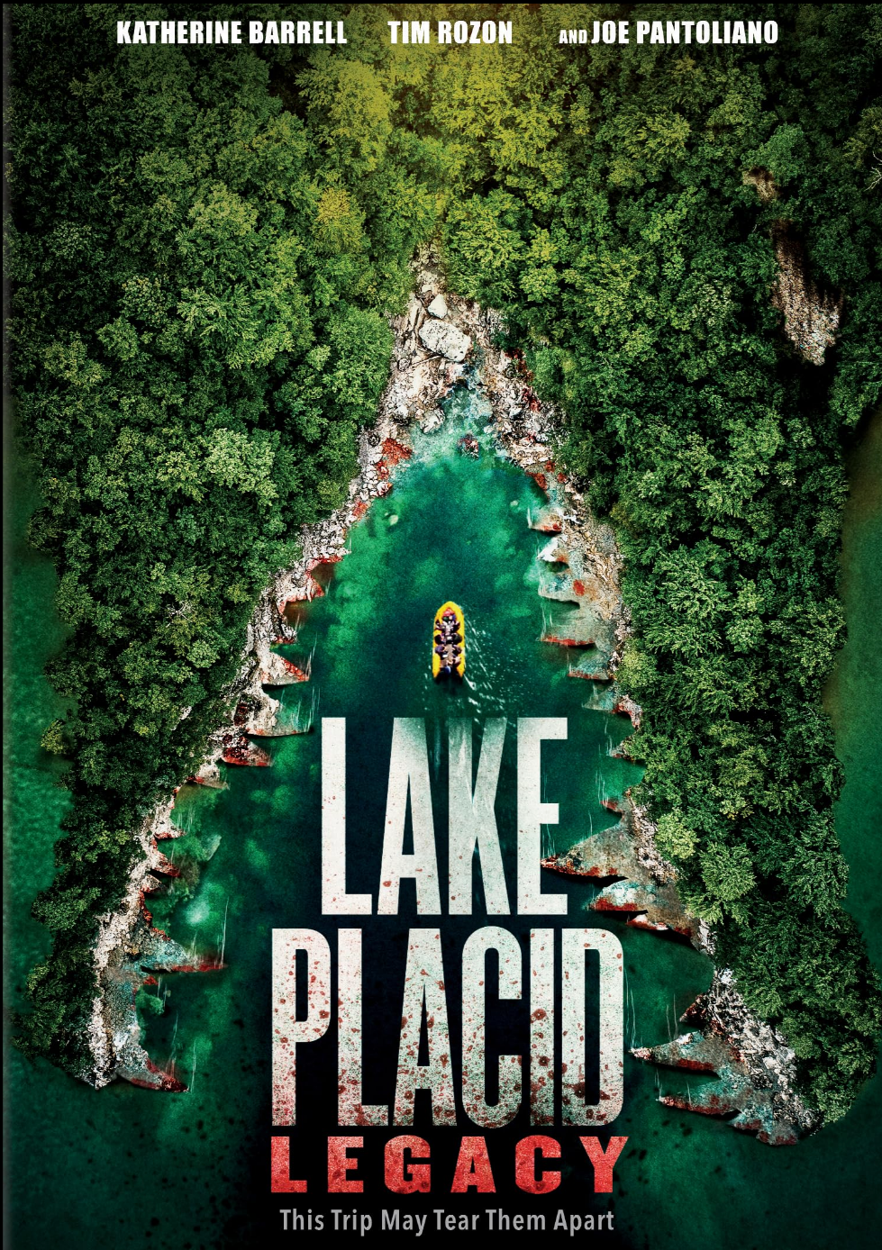 Aerial view of a boat with people in it on a narrow, rocky, tree-lined lake with steep forested banks on either side. Text at the top reads: 'Katherine Barrell, Tim Rozon, and Joe Pantaliano'. Large title text in the center says: 'Lake Placid Legacy'. A tagline at the bottom states: 'This Trip May Tear Them Apart'.