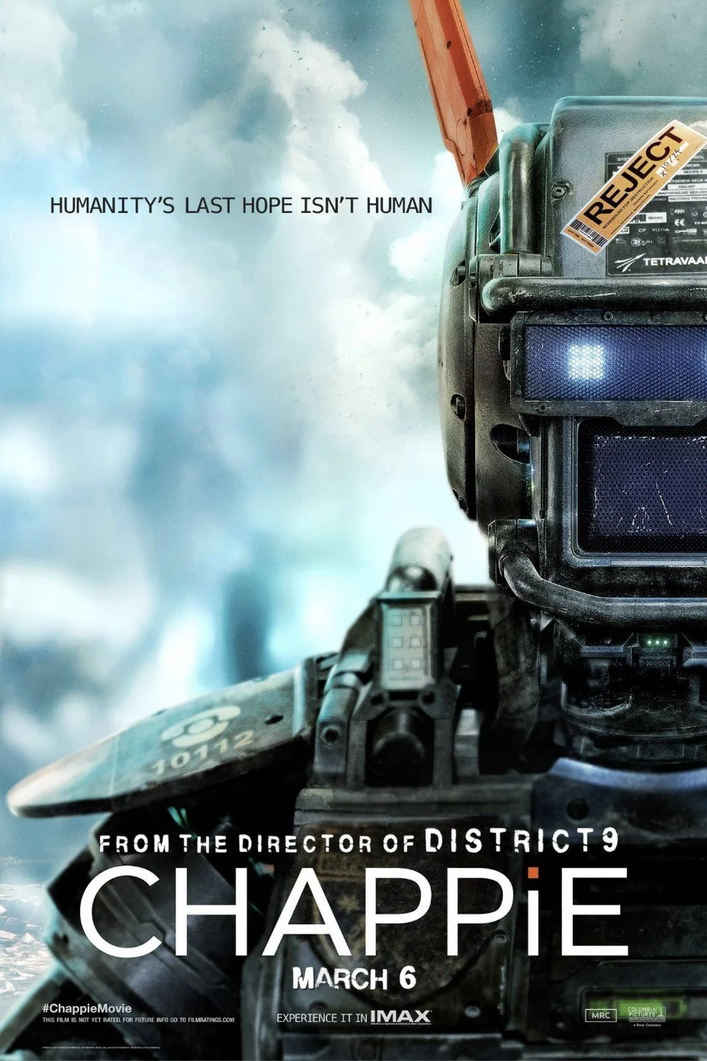 Poster for the movie 'Chappie' showing a close-up of a robot's head with a 'REJECT' sticker on it, set against a cloudy sky background with the text 'HUMANITY'S LAST HOPE ISN'T HUMAN'.