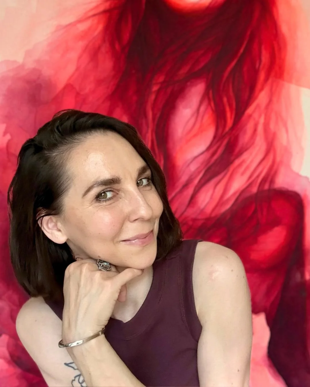 Künstlerin Portrait mit rotem Hintergrund- Kunstwerk im HintergrundMischa Sugar
