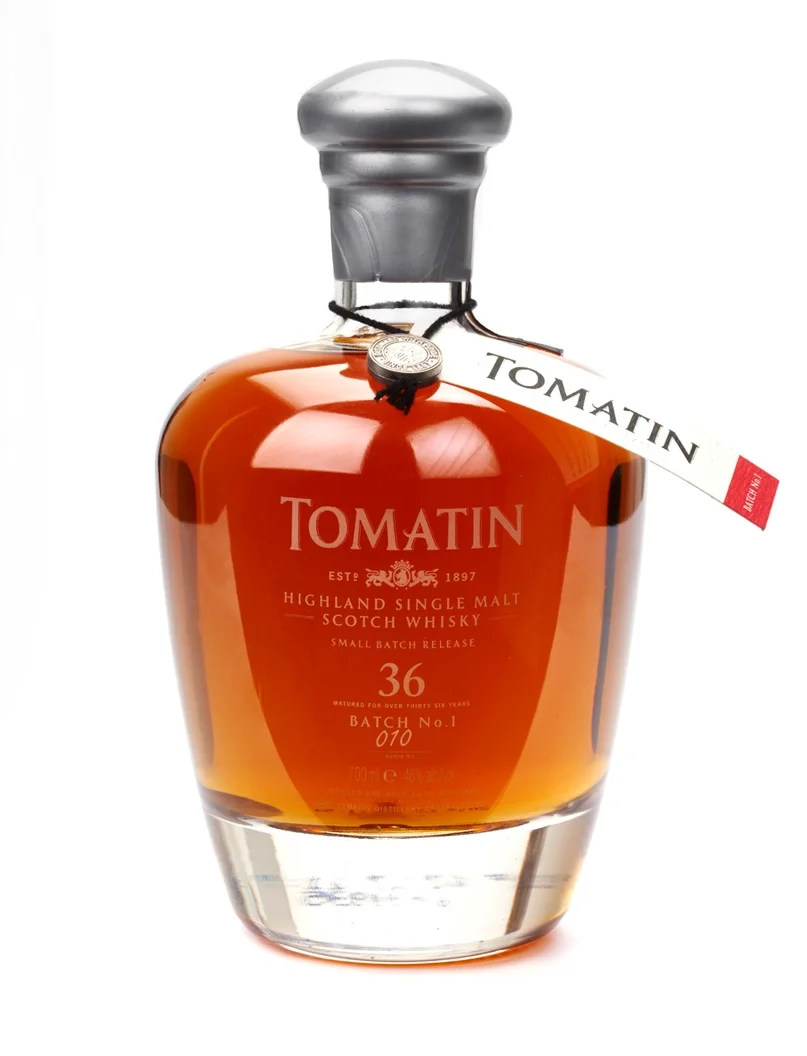 A bottle of Tomatin Highland Single Malt Scotch Whisky with a silver cap and a tag attached.
