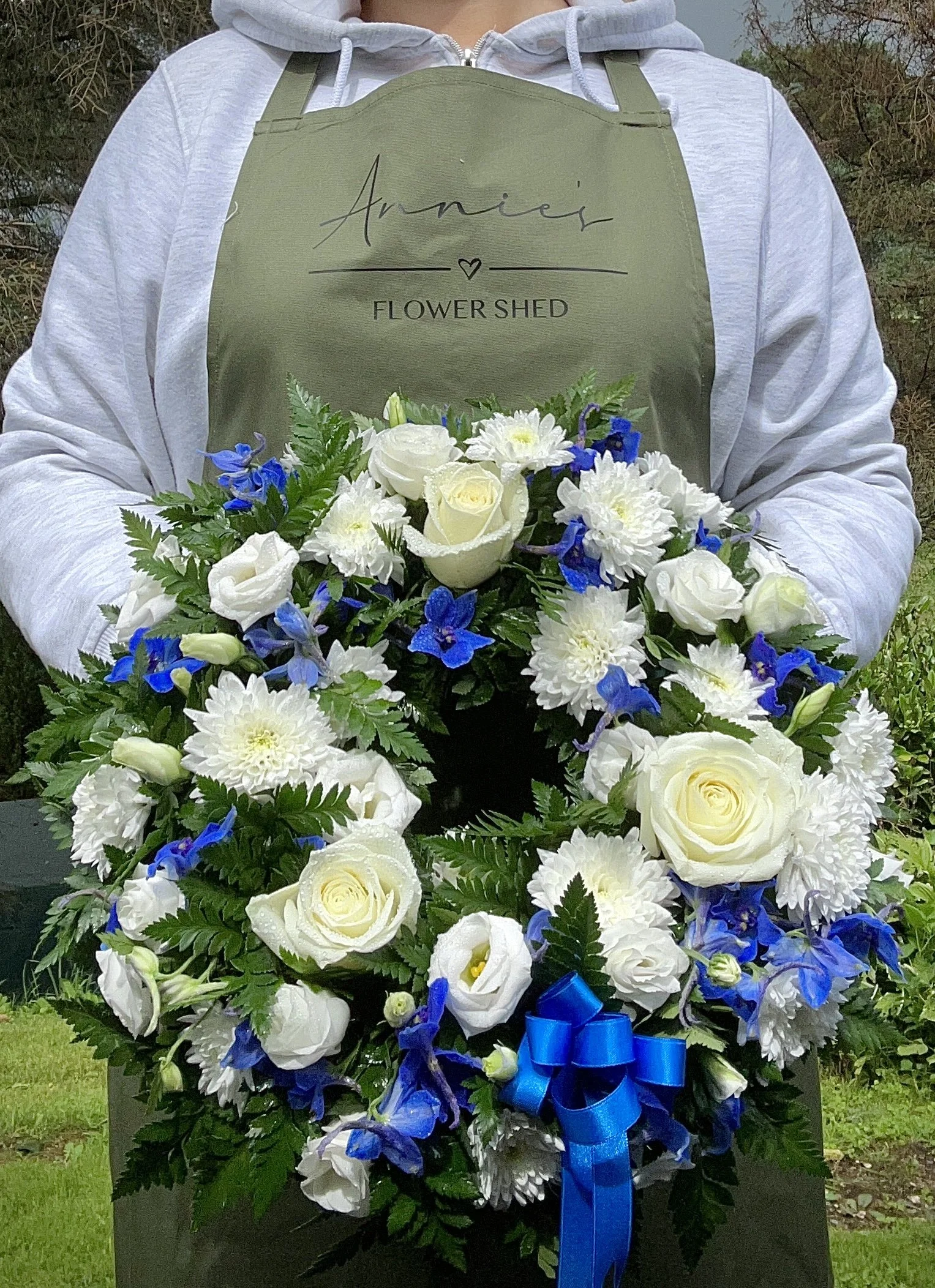 large white and blue flower wreath made by Annie's Flower Shed.