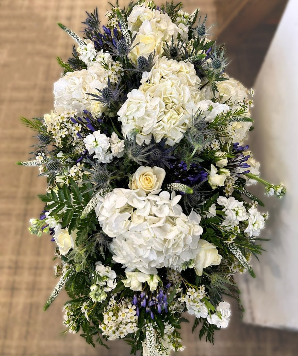 A bouquet of white and purple flowers including hydrangeas, roses, and other filler flowers.