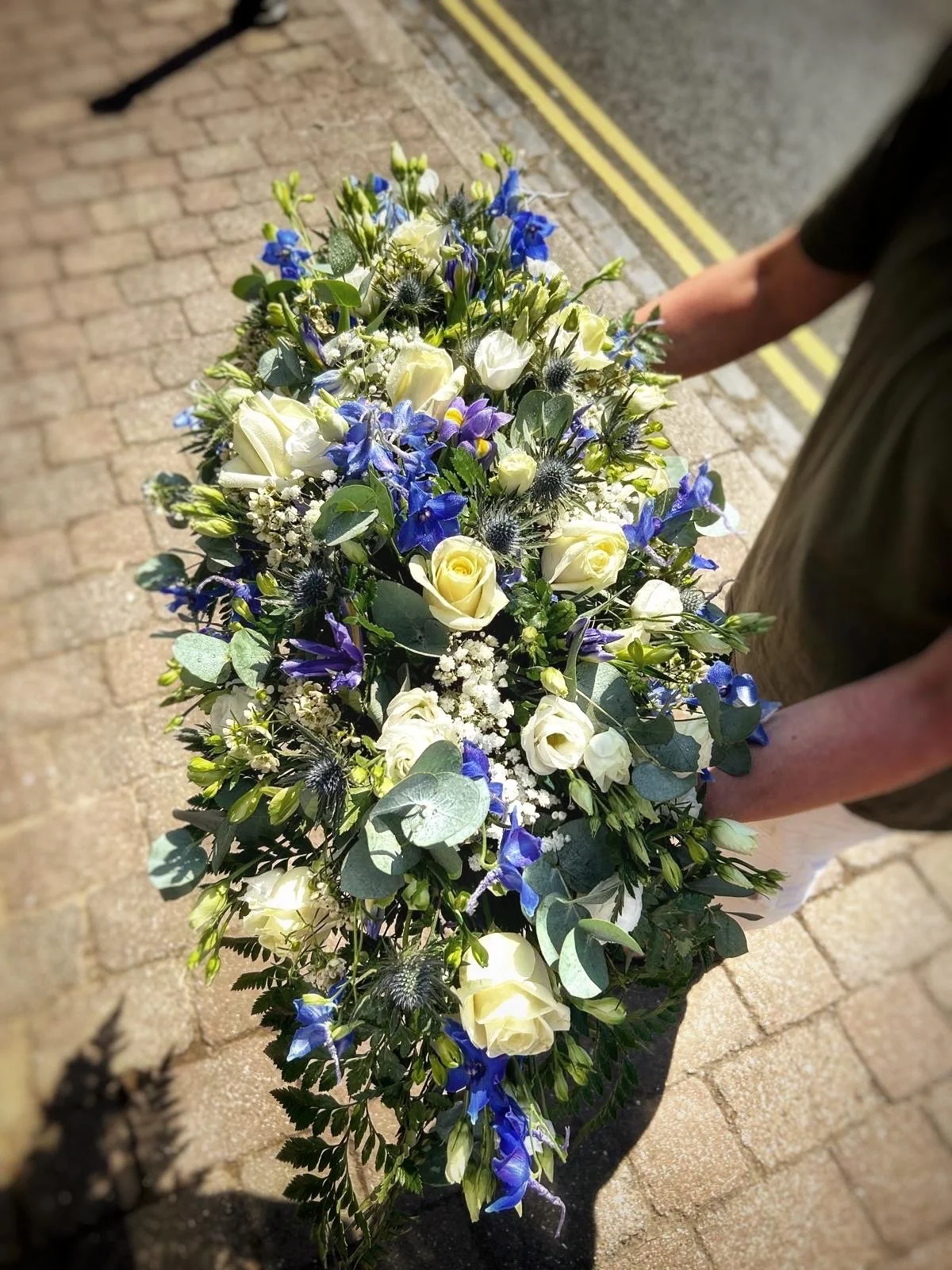 casket spray blue & white made by Annie's Flower Shed.