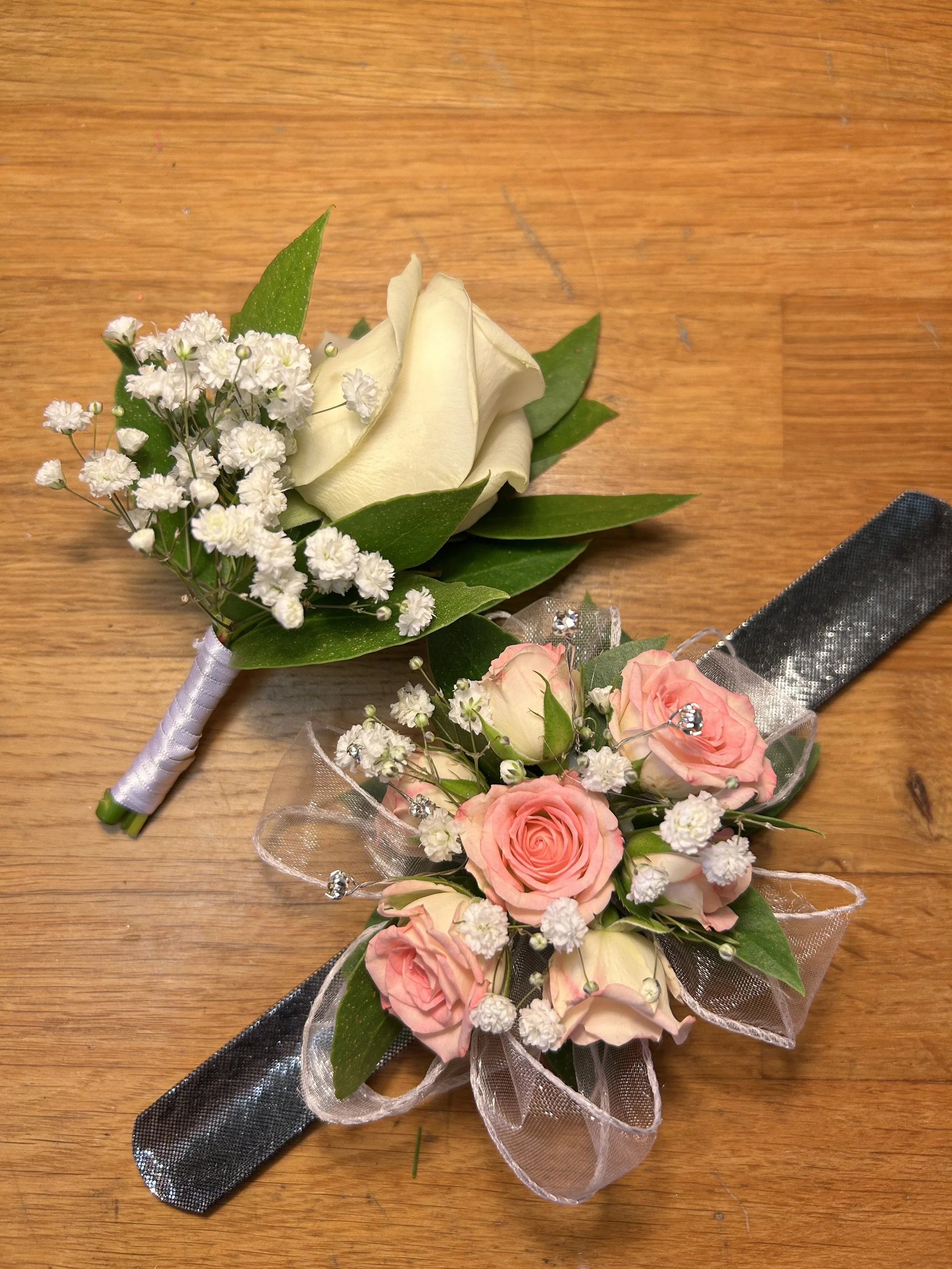 A pink rose corsage with a small white buttonhole. made by Annie's Flower Shed.