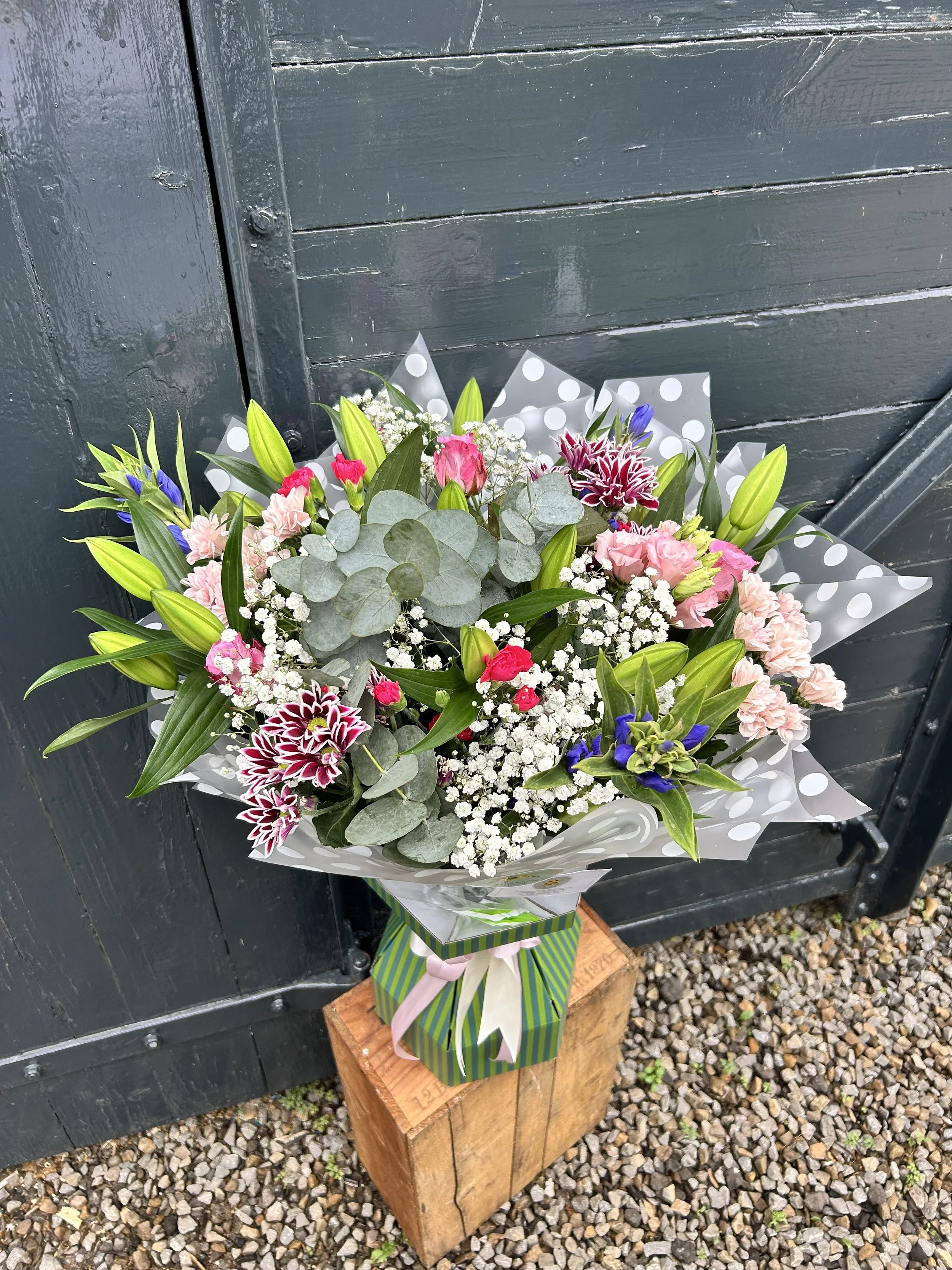 A colorful flower bouquet with pink, white, purple, and green flowers 