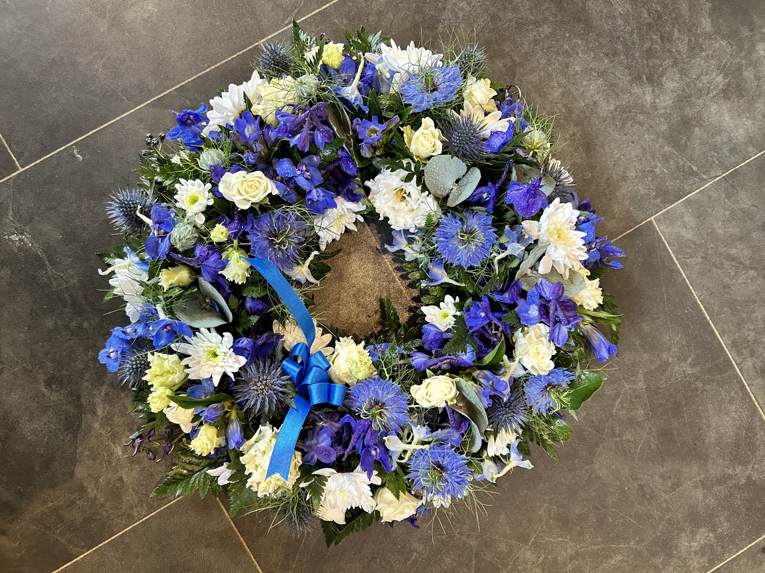 white and blue funeral wreath
