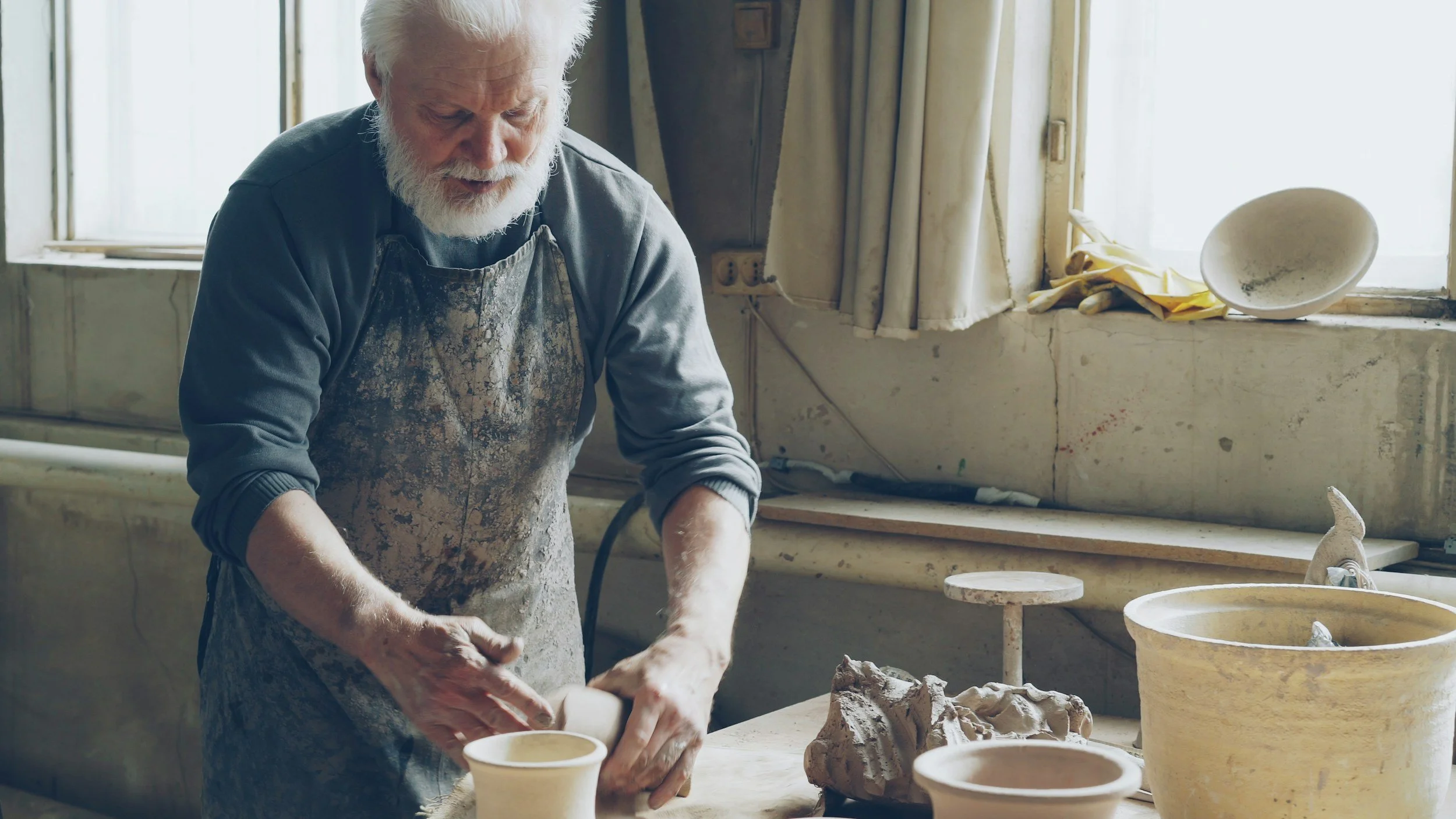 Older man practising ceramics.