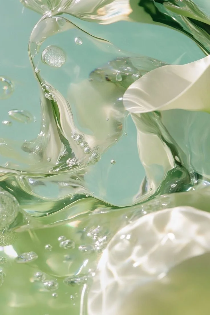 Abstract close-up of white roses submerged in clear water with bubbles and light reflections.