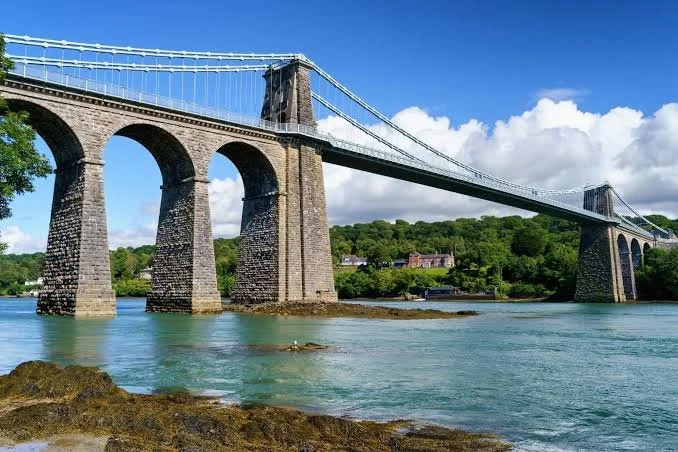 Huge stone bridge (Menai Bridge to Anglesey in Wales) stretching over the water.