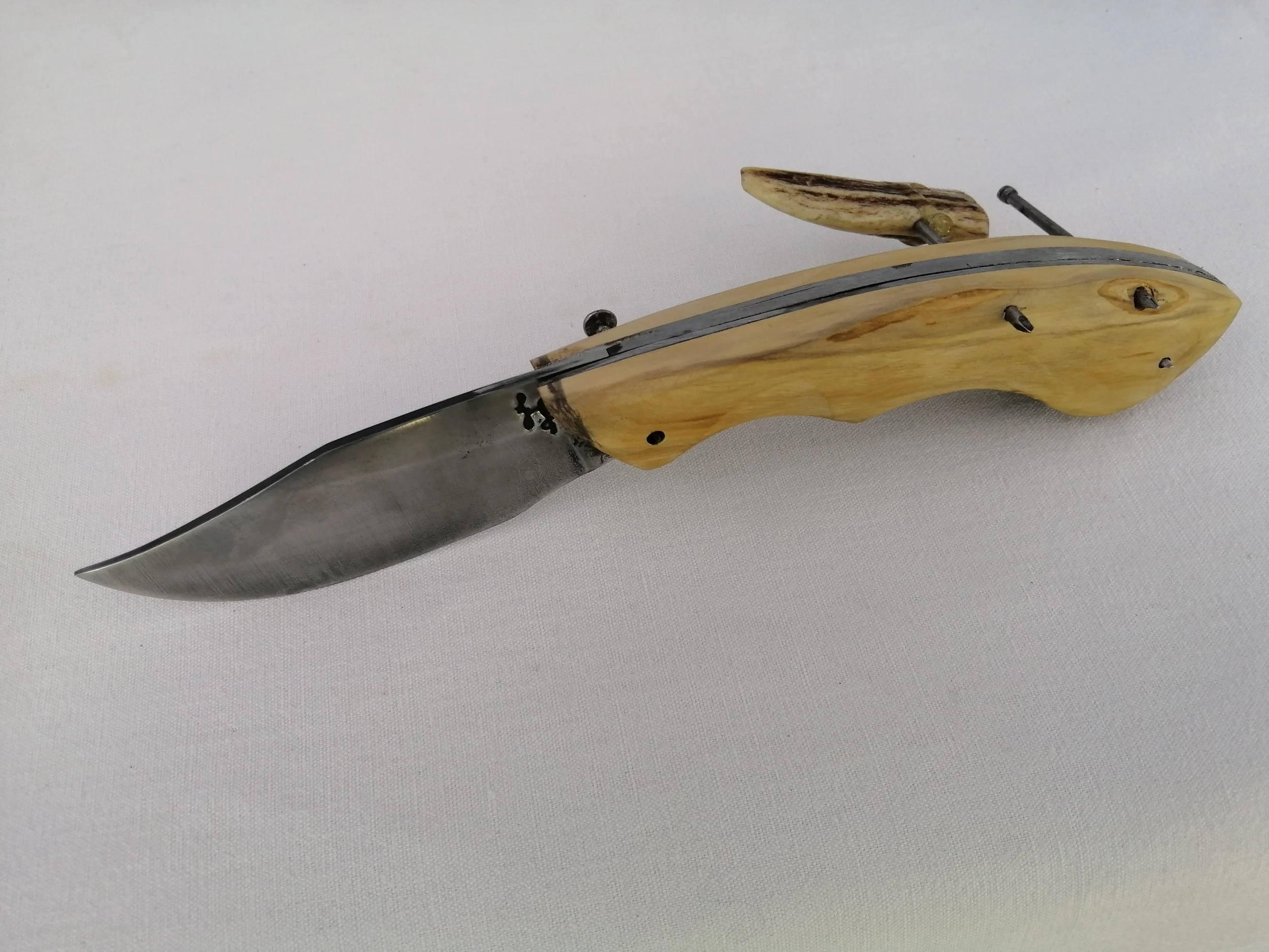 Couteau avec poignée en bois et lame en acier carbone sur un fond blanc.