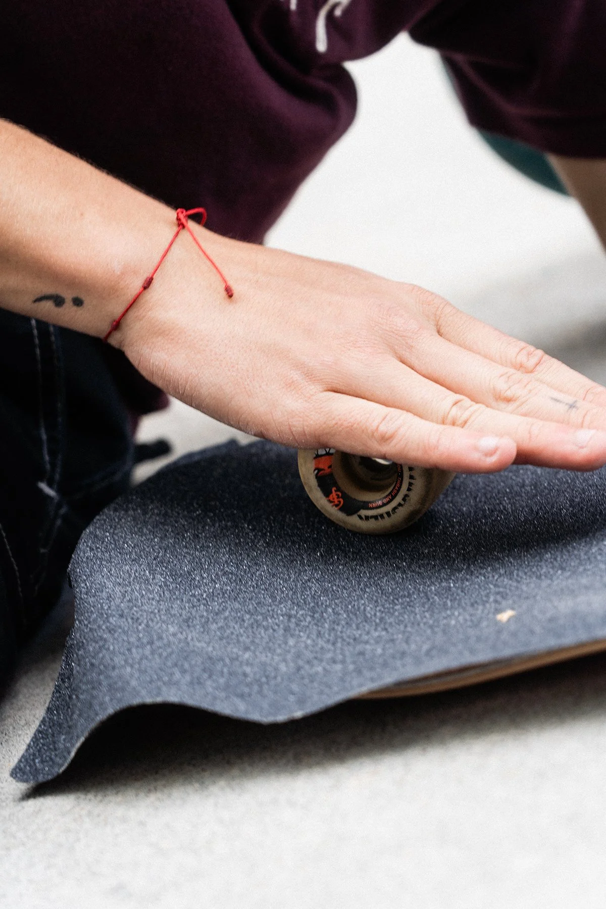close up image of someone rolling a wheel on grip tape to flatten it.