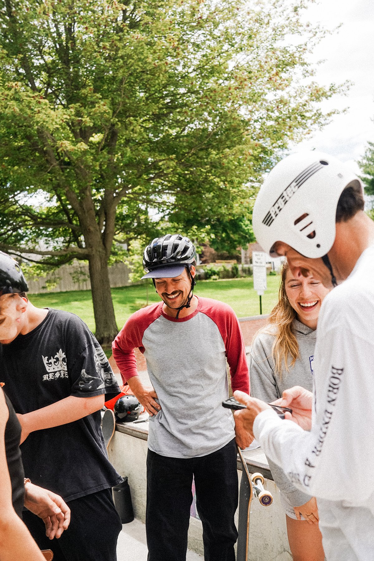 Skate to relate staff candid photo laughing in a green area of a skatepark.