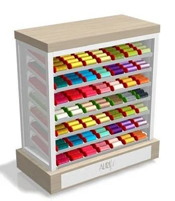 A wooden and glass display case filled with colorful soap bars arranged in rows.