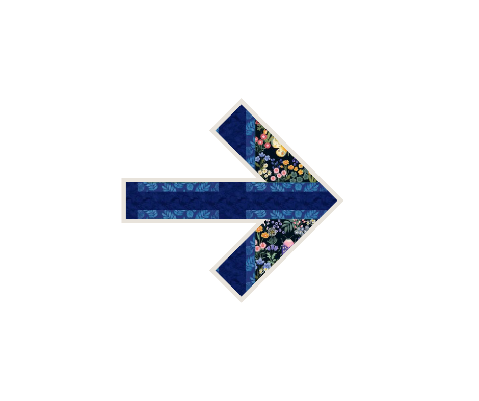 A quilt made into a right-facing arrow shape with a floral pattern and dark blue fabrics