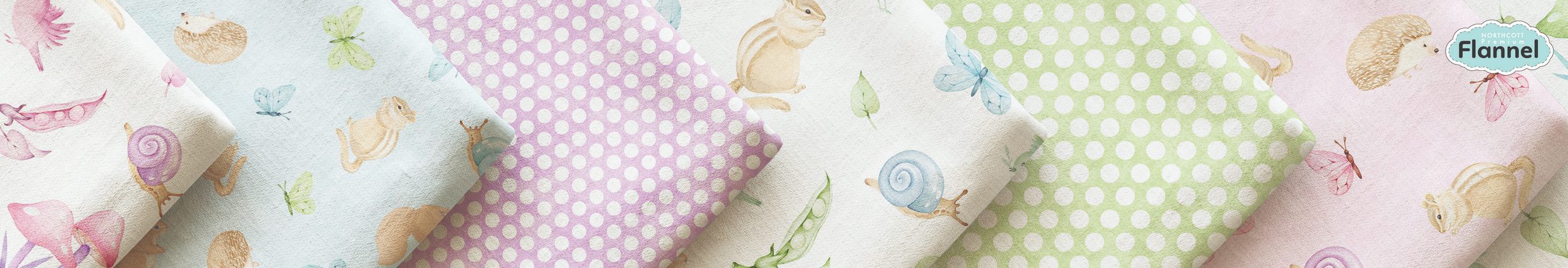 Selection of pastel-colored flannel fabric with printed animal and nature designs, including snails, mice, butterflies, leaves, and mushrooms.