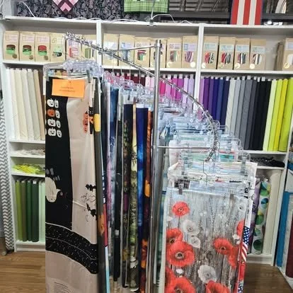 Display of decorative sheers and curtains with a floral and star pattern in a home decor store.
