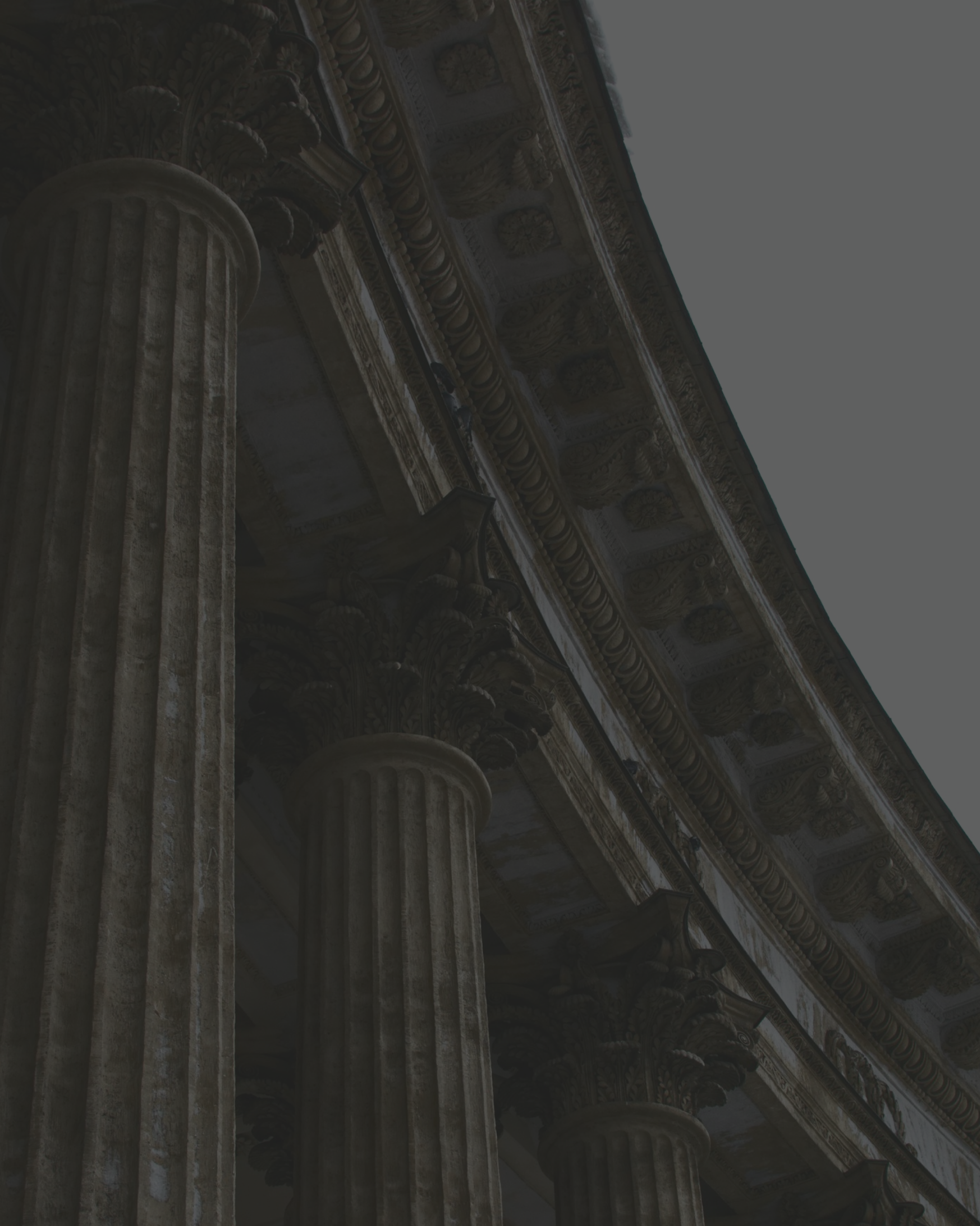 Close-up of Classical Greek or Roman stone columns with intricate architectural details and carvings.