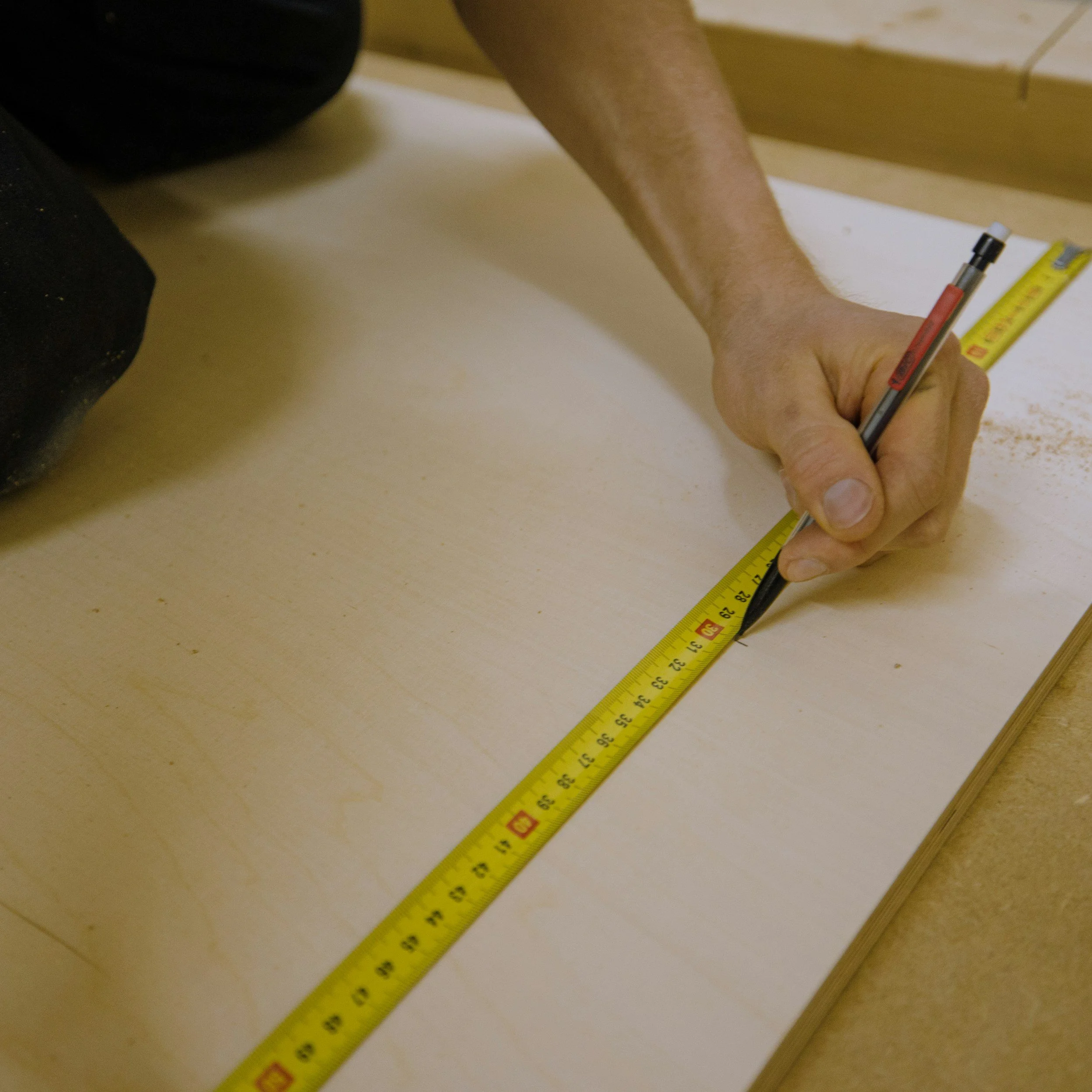 Tape measure, measuring a board on a workbench