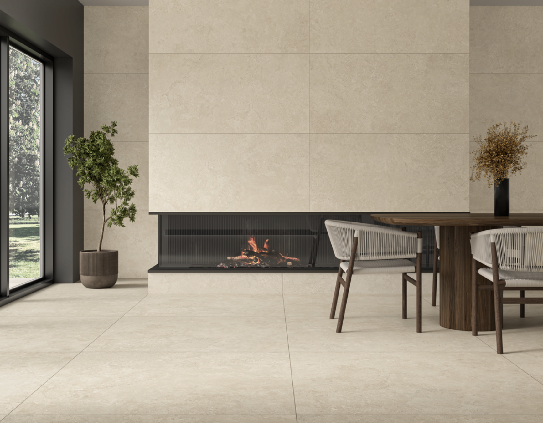 Interieur met een moderne open haard, een ronde houten eettafel met vier witte stoelen, een zwarte vaas met gedroogde bloemen op de tafel, een groen plant in een pot, grote ramen met zicht op een tuin, beige tegelvloer en een muur met een lichte bakstenen uitstraling.
